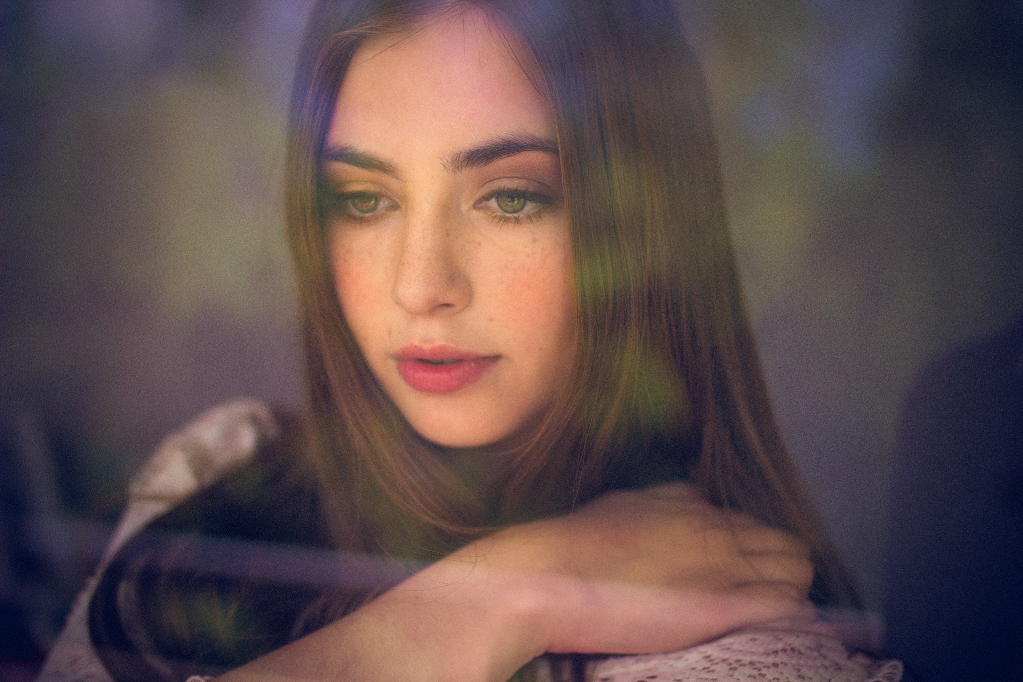 Young woman with freckles looking down HD Wallpaper