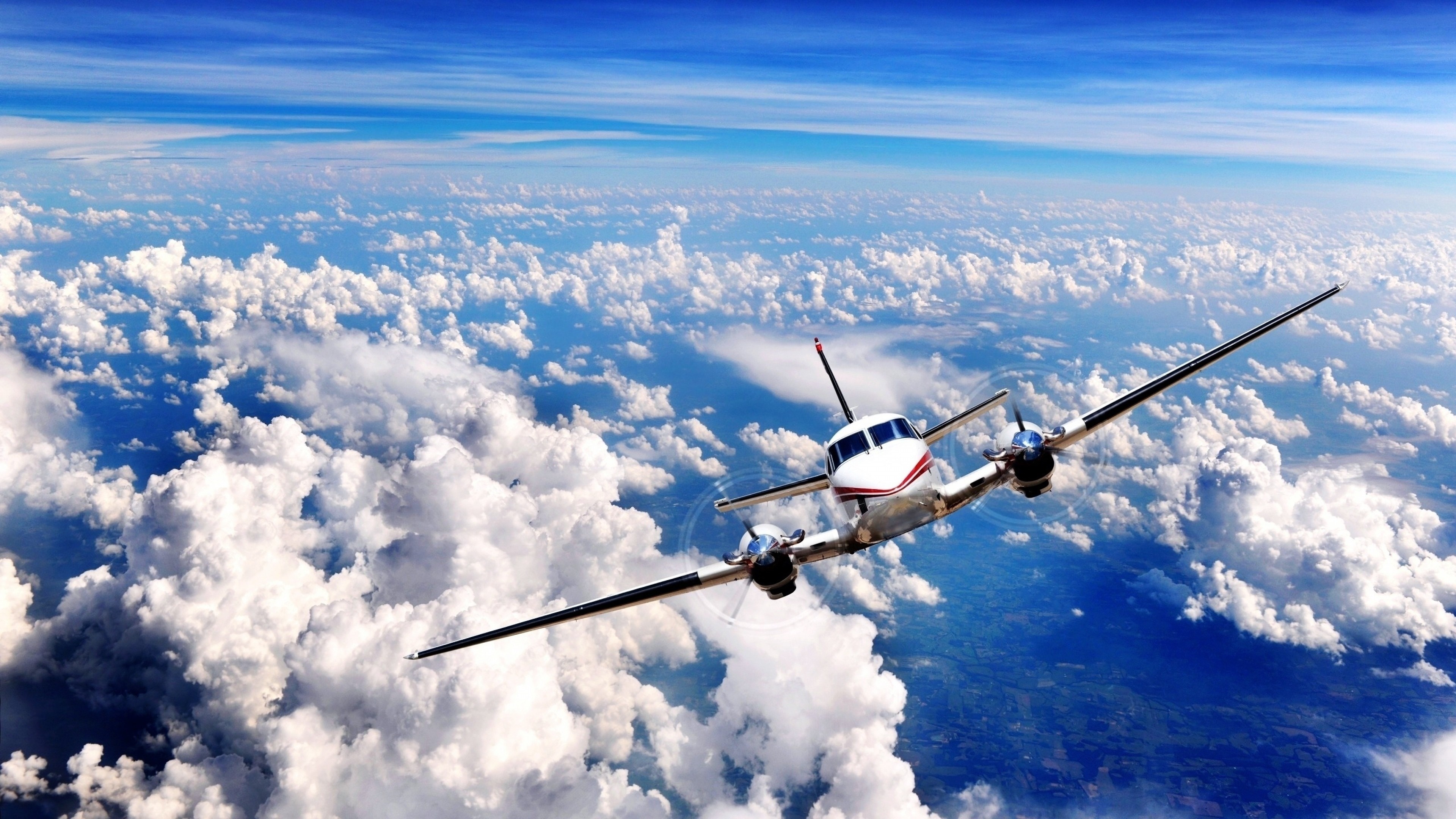 Twin-engine airplane flying above clouds HD Wallpaper