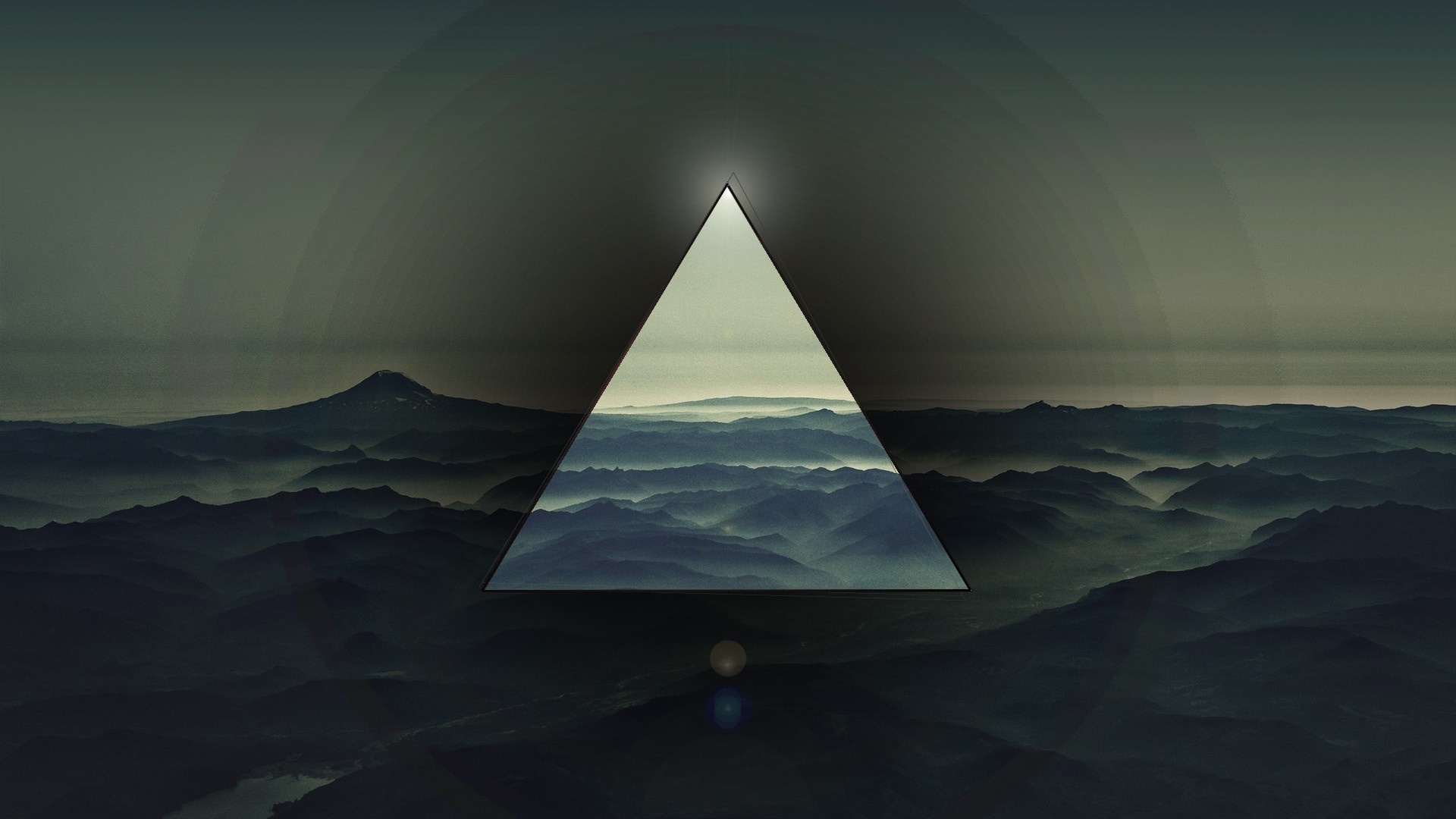 Triangle framing misty mountains and a distant peak HD Wallpaper