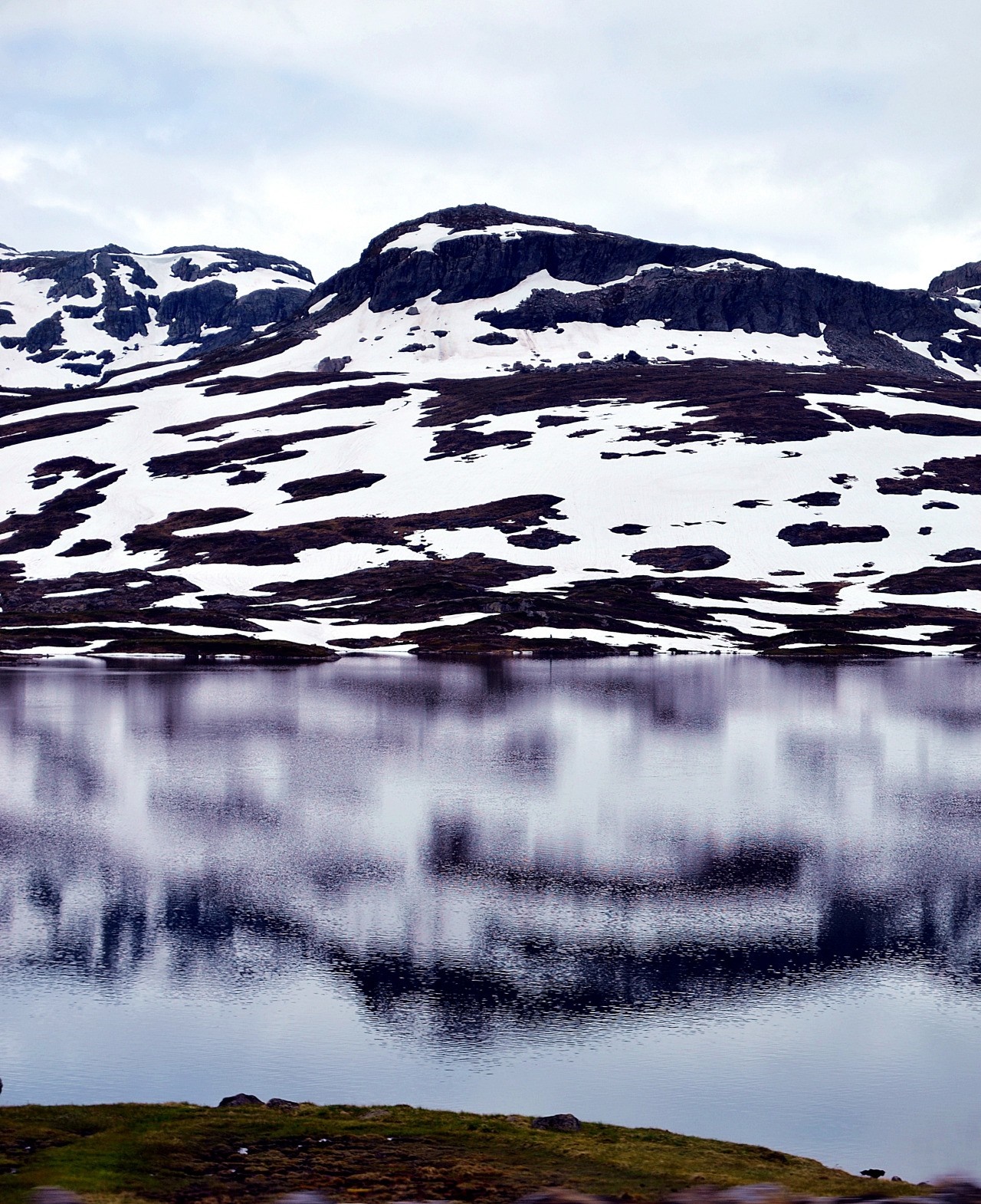 Snow-covered mountains reflected in a calm lake HD Wallpaper
