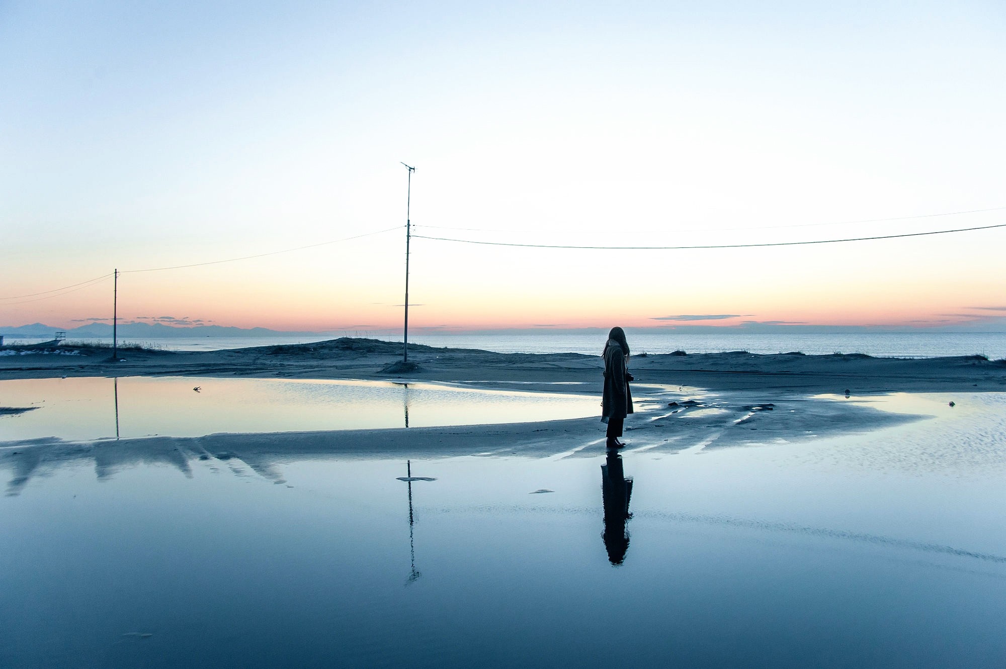 Woman standing by the sea at dawn with reflection HD Wallpaper