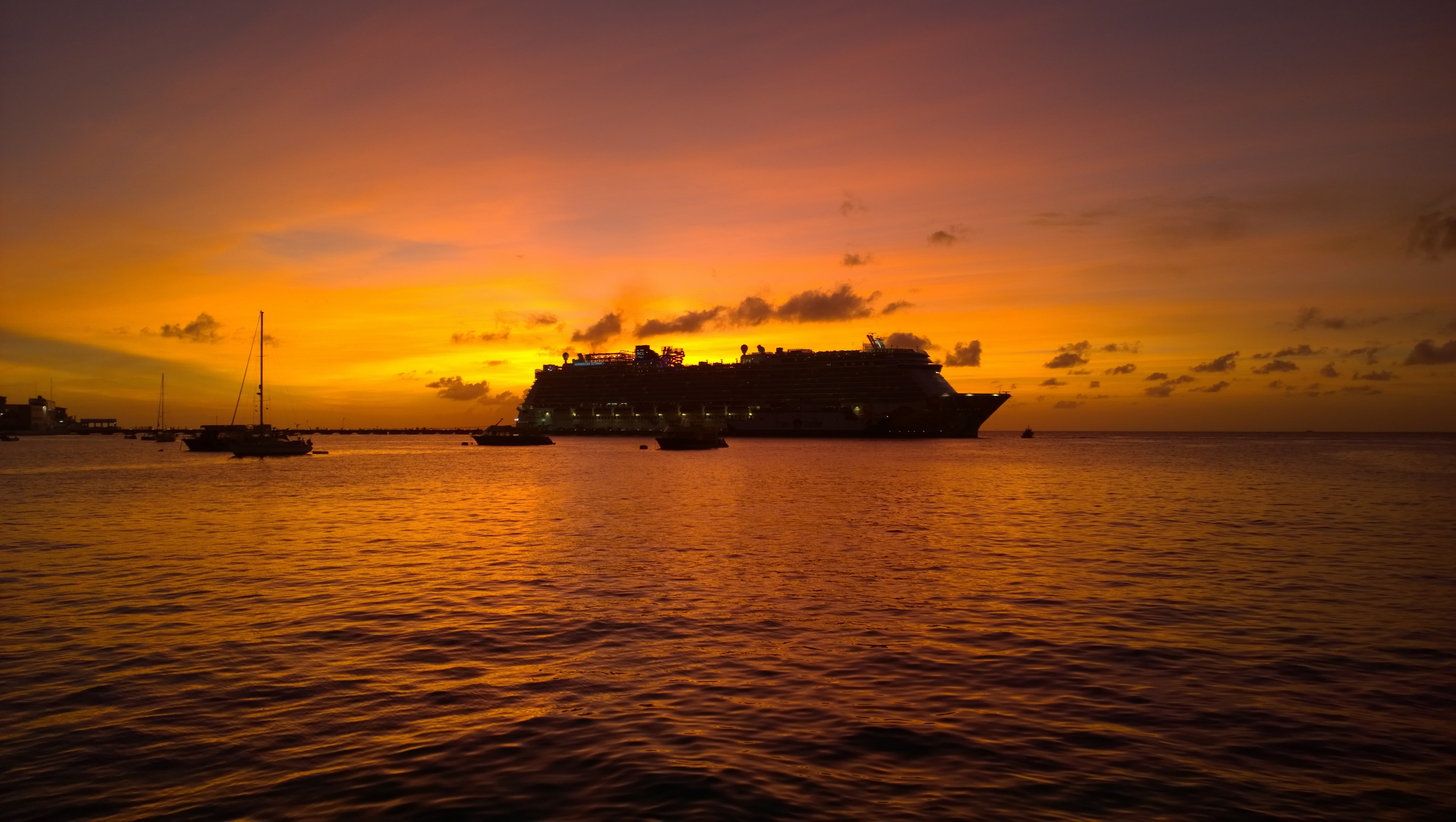 Cruise ship and sailboats at sunset over the ocean HD Wallpaper