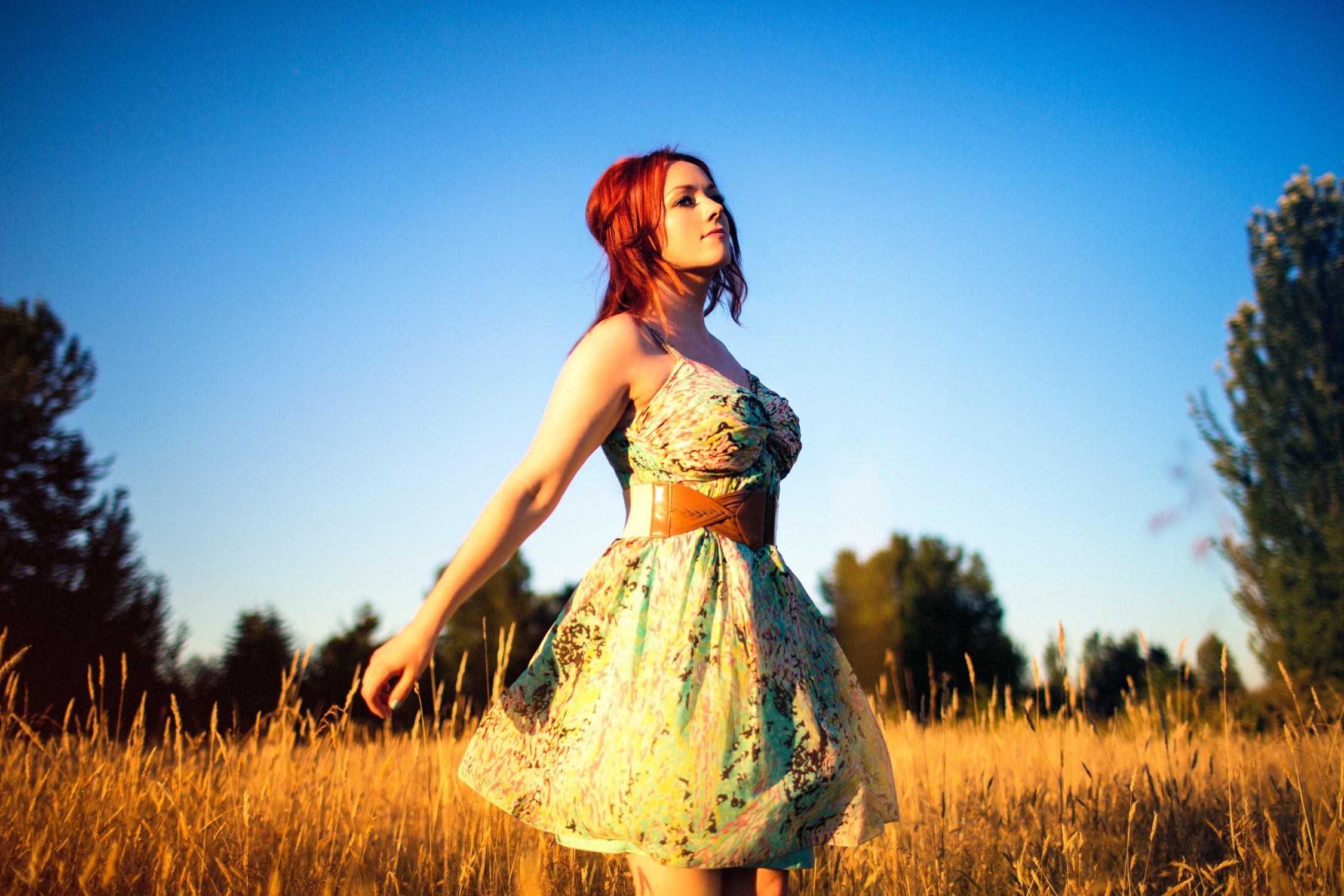 Woman in a dress in a field at sunset HD Wallpaper