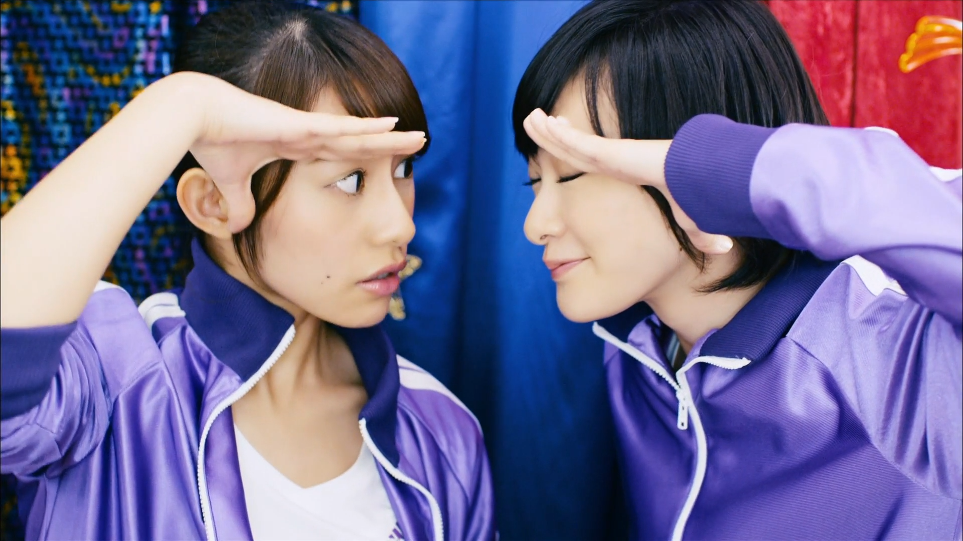 Two women in purple tracksuits looking to the side HD Wallpaper
