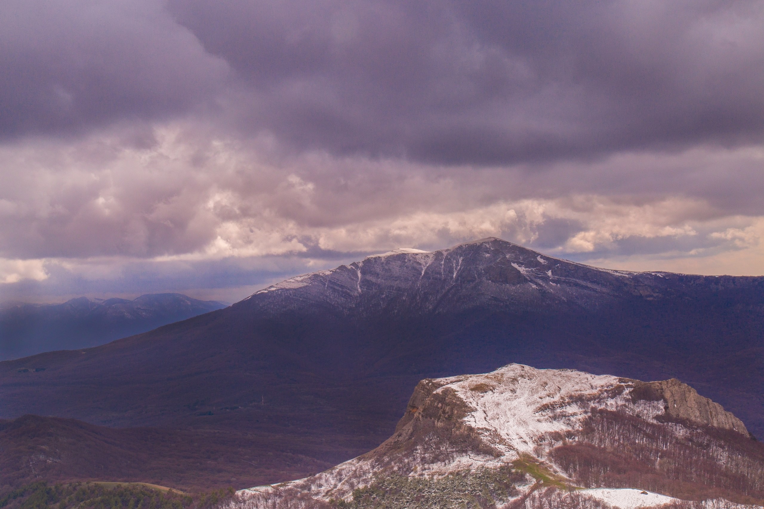 Snow-capped mountains under a cloudy sky HD Wallpaper