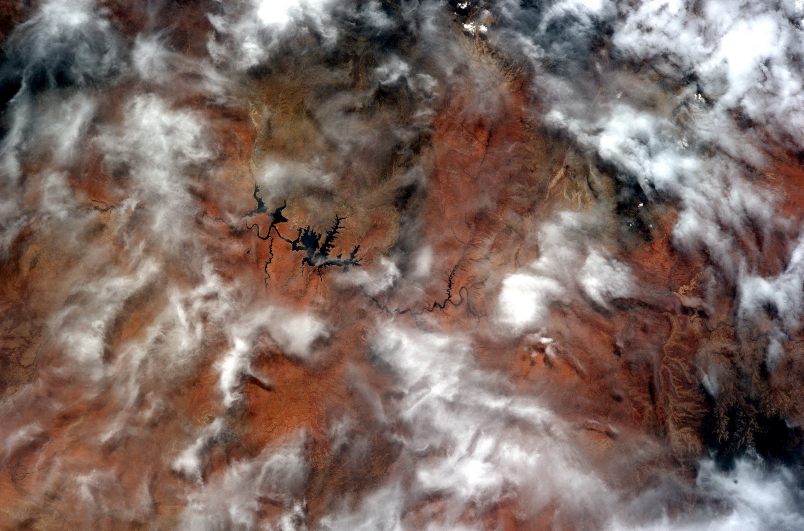 Satellite view of a river and clouds over arid land HD Wallpaper