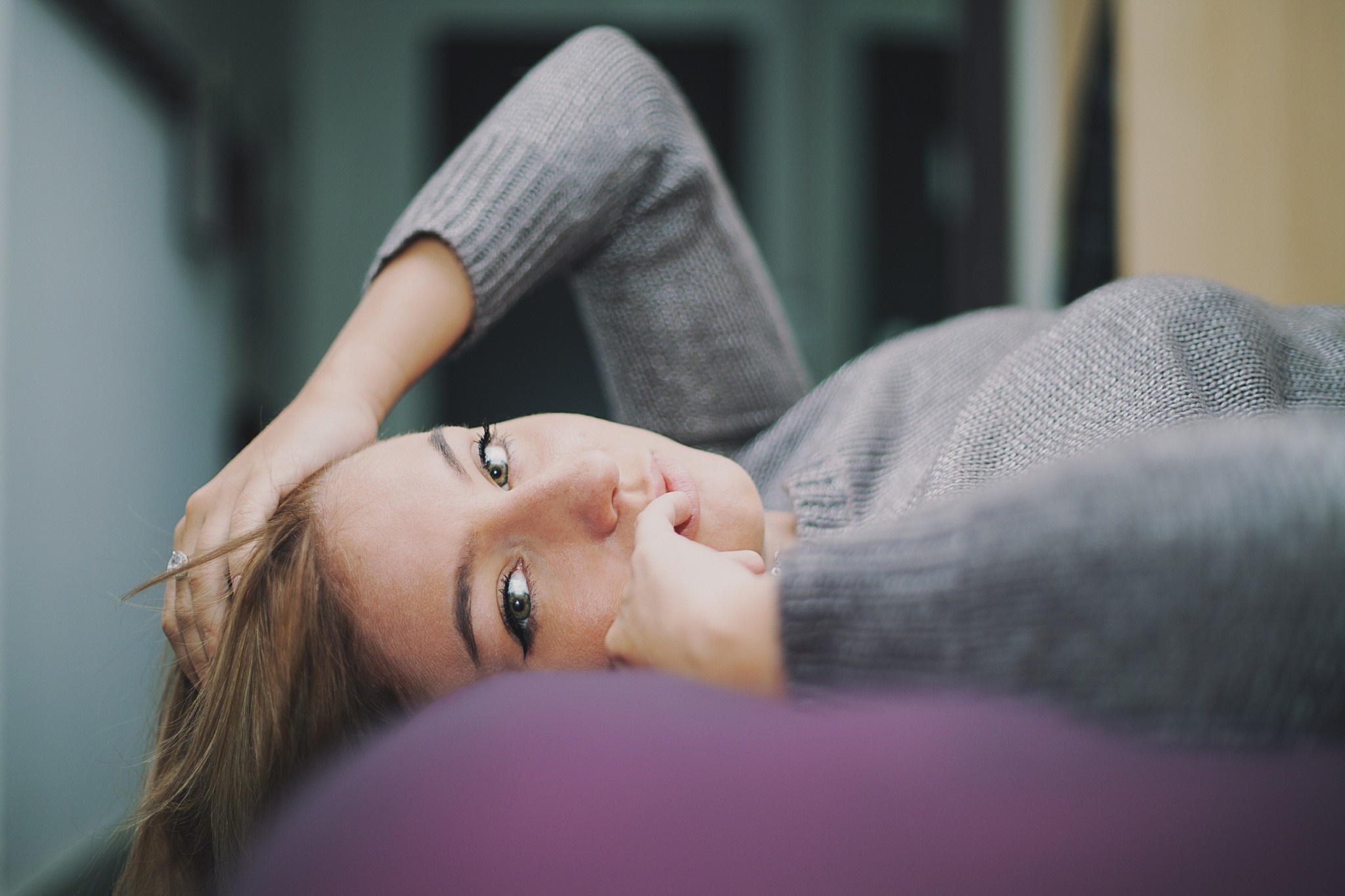 Woman lying down, hand on head, looking at viewer HD Wallpaper