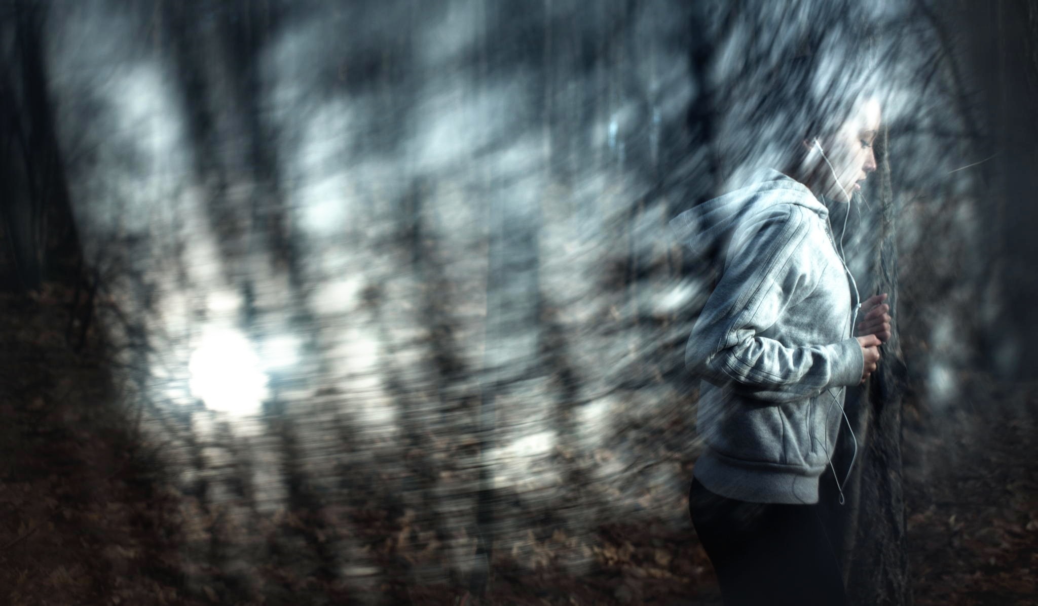 Woman with headphones in a blurry forest HD Wallpaper