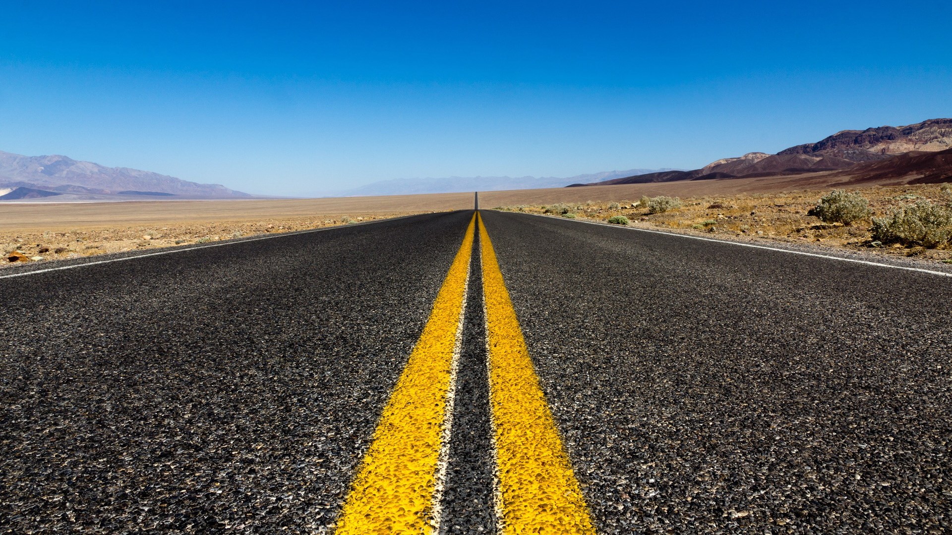 Empty desert highway with double yellow lines HD Wallpaper
