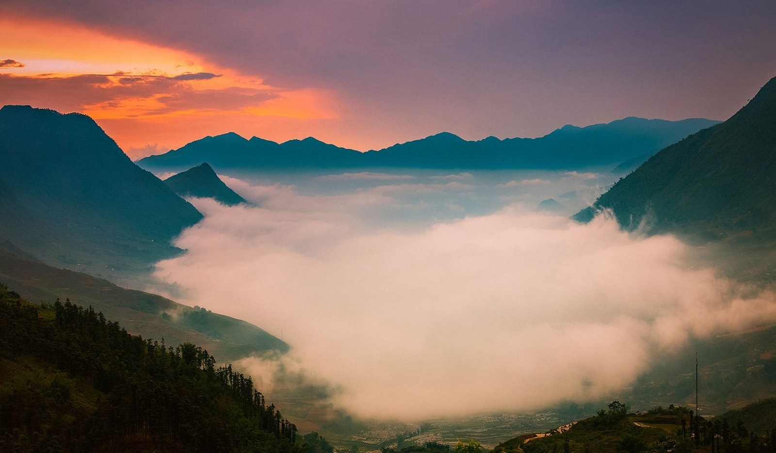 Mountains shrouded in mist at sunset HD Wallpaper