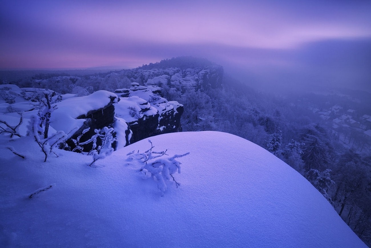 Snowy landscape with cliffs and mist at dawn HD Wallpaper