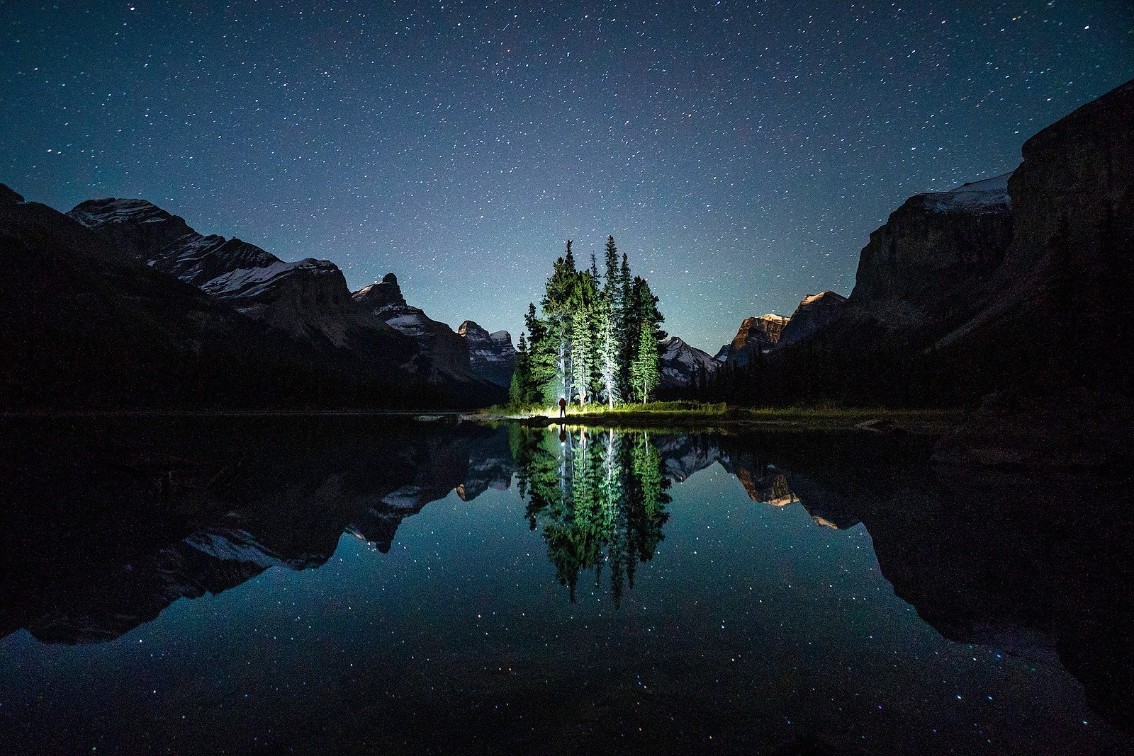 Island of trees reflected in a lake under a starry sky HD Wallpaper