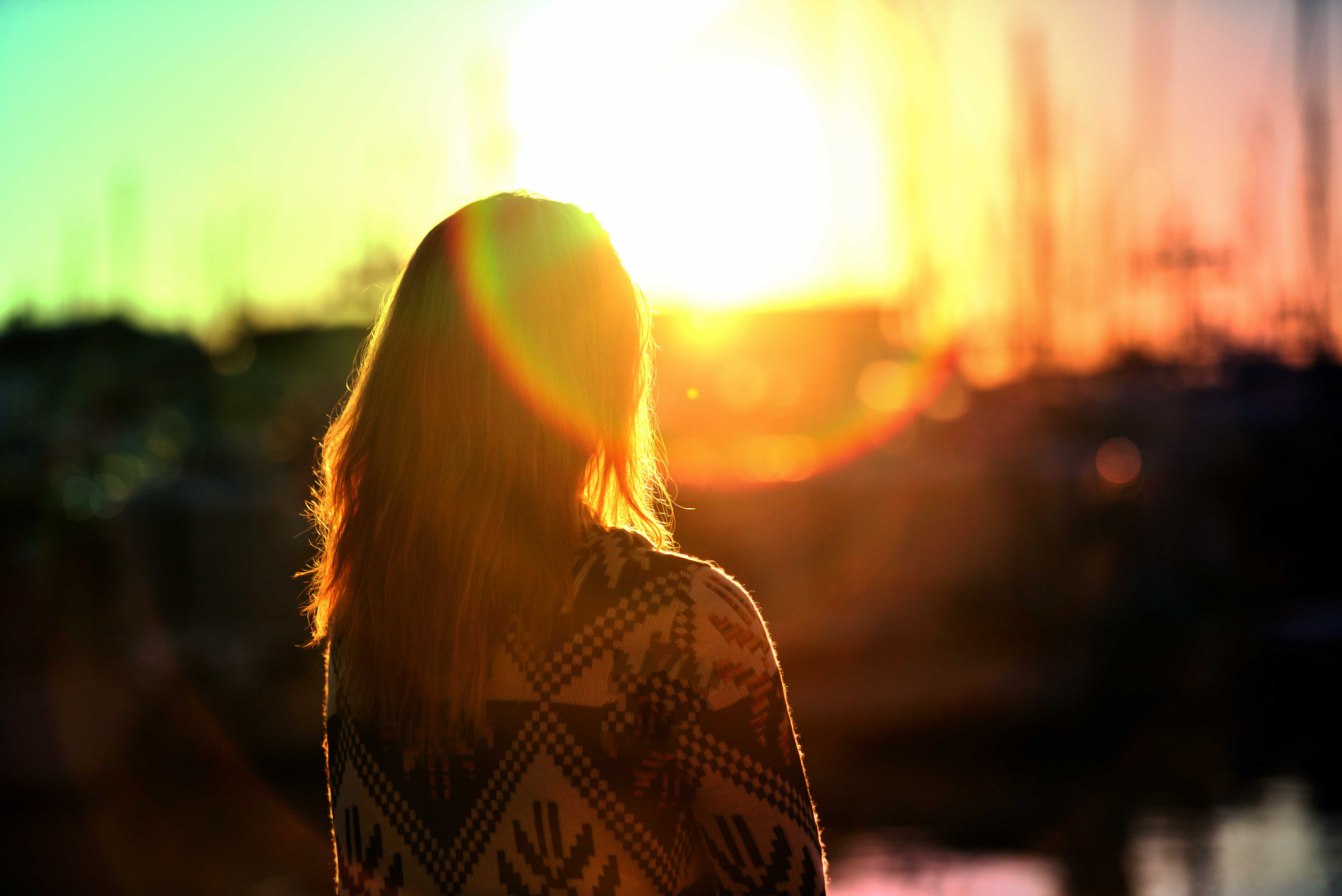 Woman in sweater watching sunset with lens flare HD Wallpaper