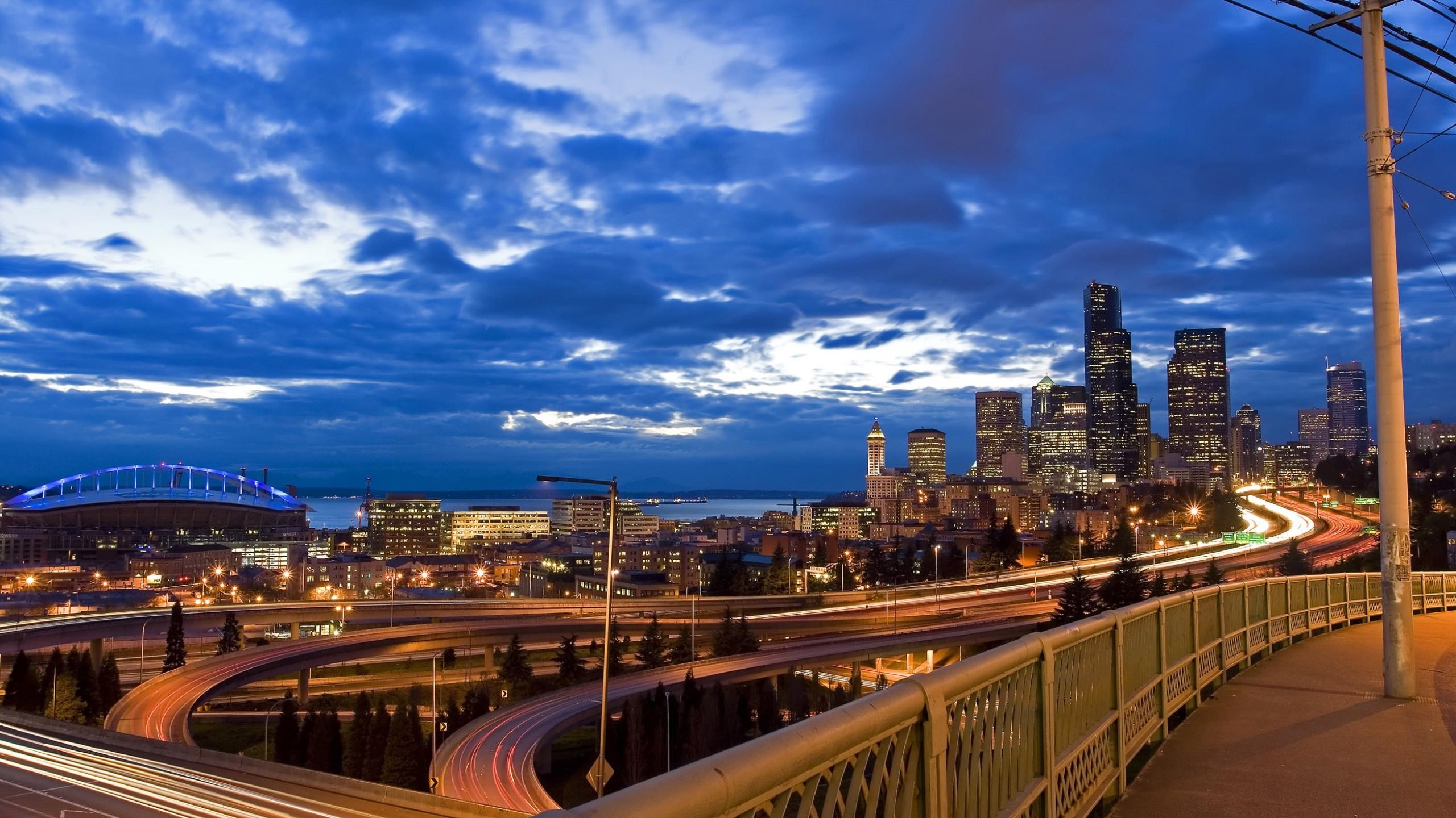 Seattle cityscape at dusk with stadium and highway HD Wallpaper