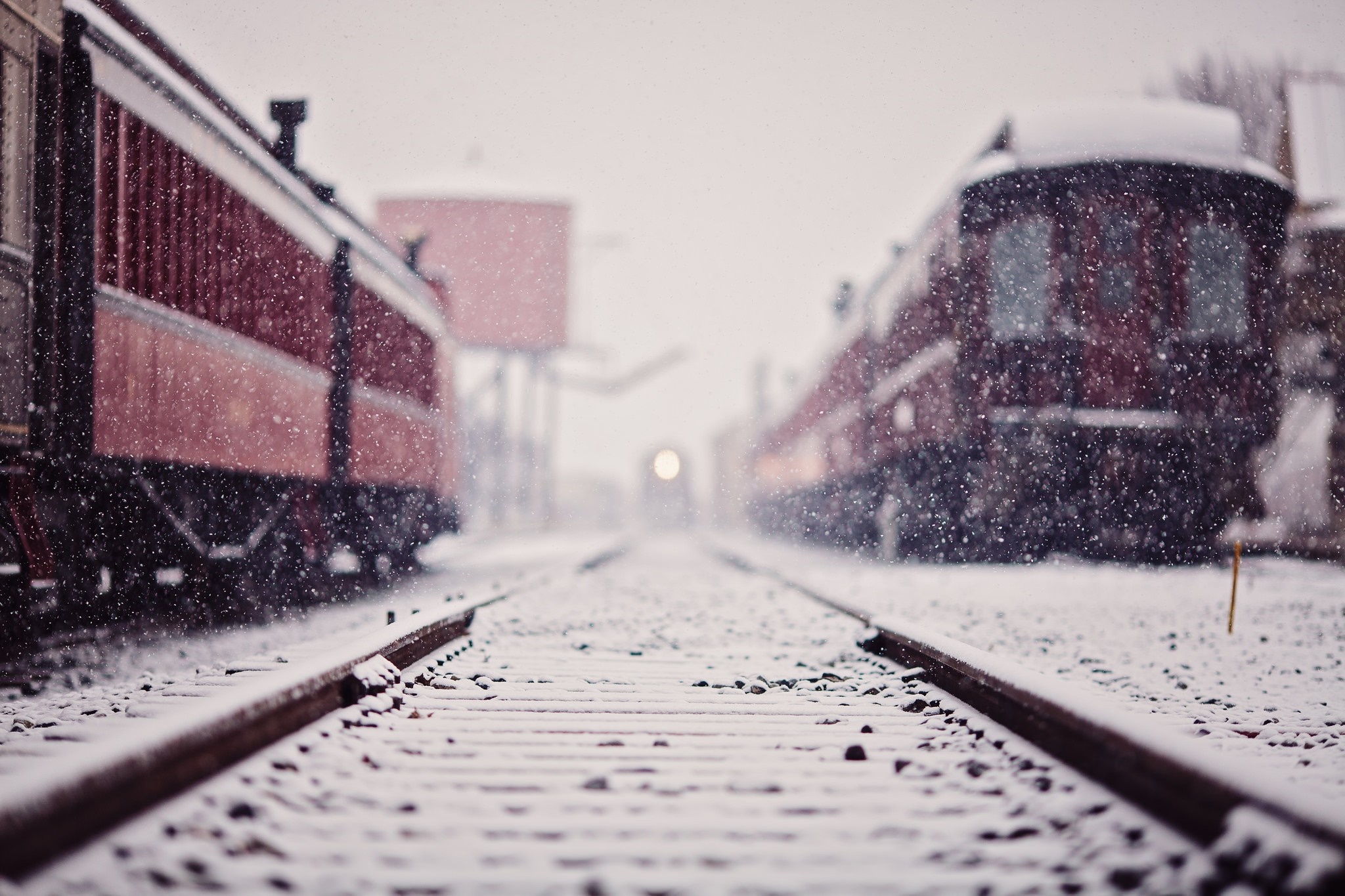 Trains on snowy railway tracks during a blizzard HD Wallpaper