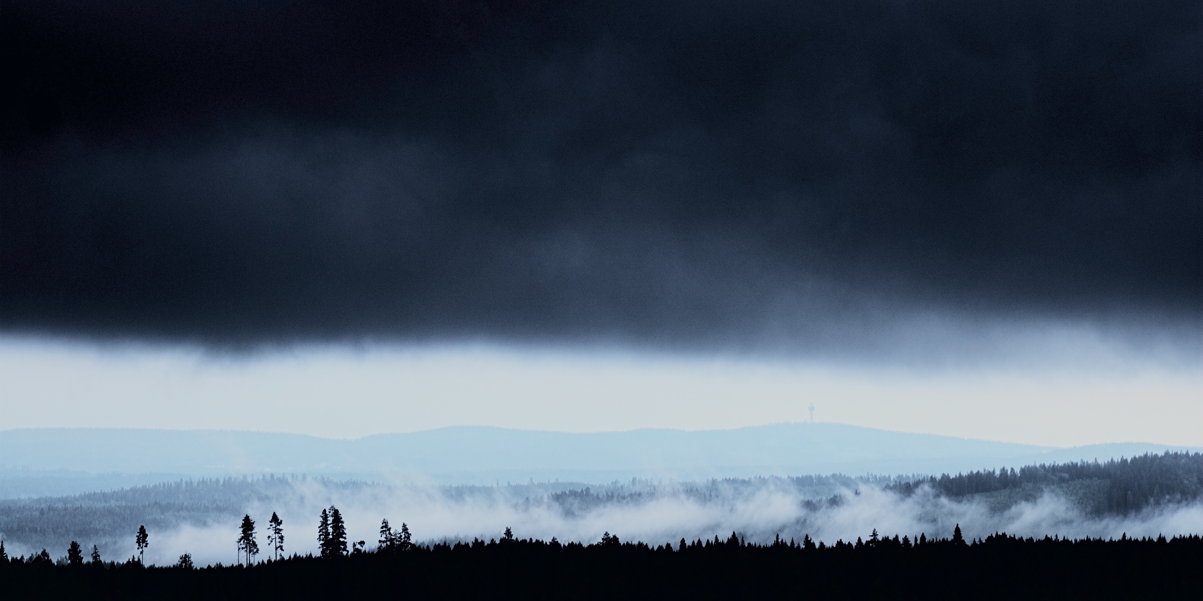 Dark storm clouds over misty forest and mountains HD Wallpaper