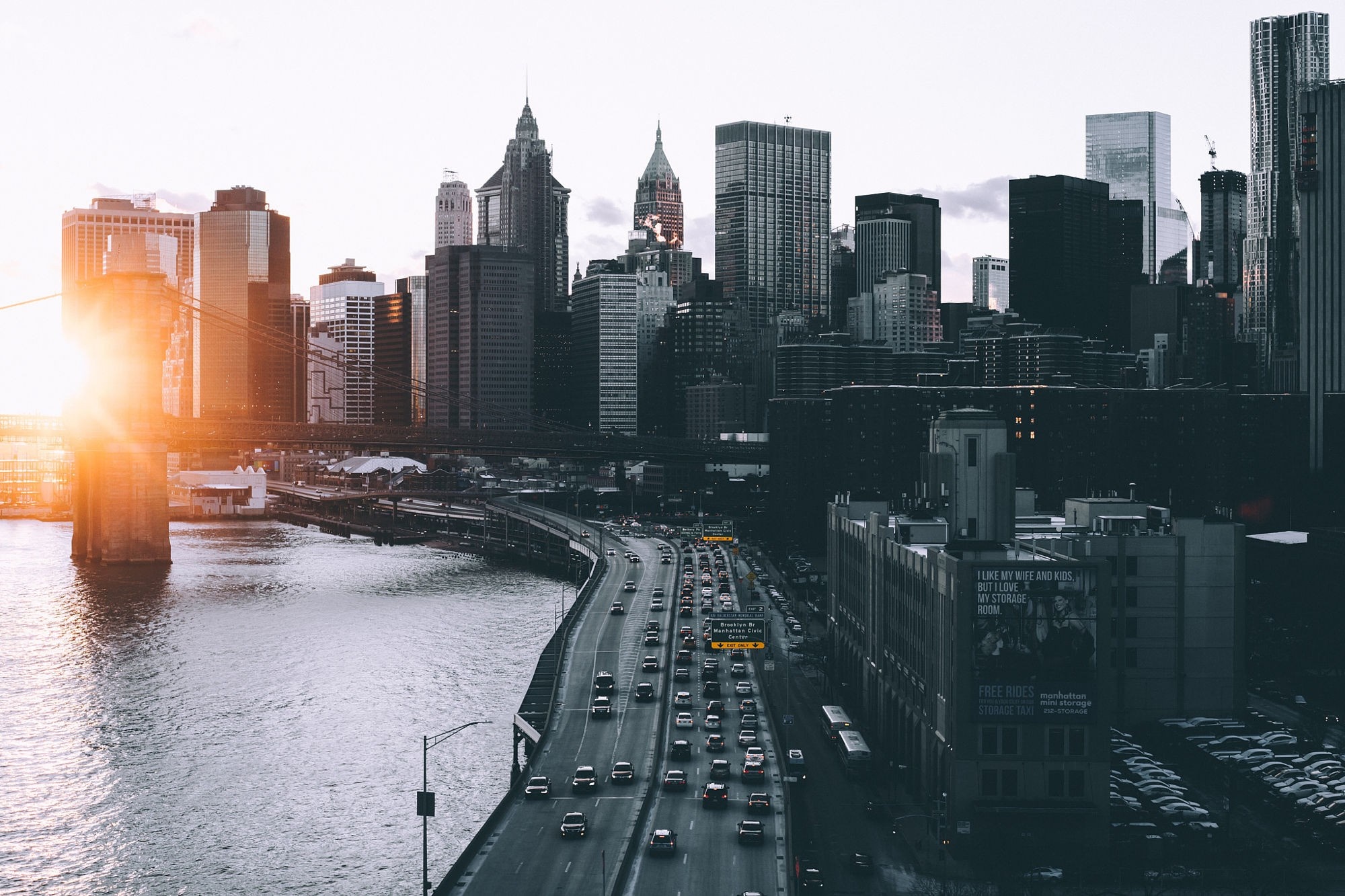 New York City skyline with Brooklyn Bridge and traffic at sunset HD Wallpaper