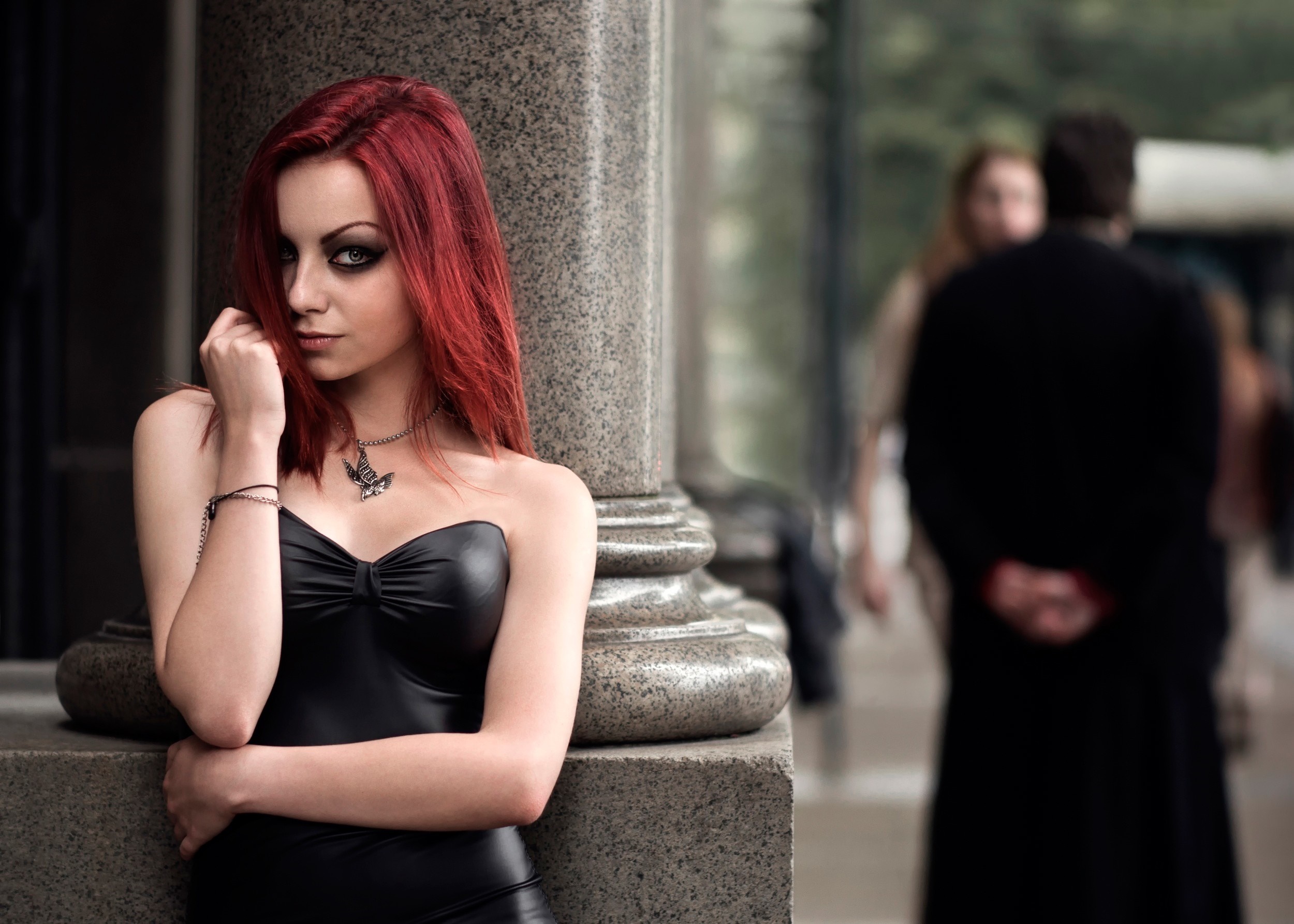 Woman with red hair in a black dress posing by a pillar HD Wallpaper