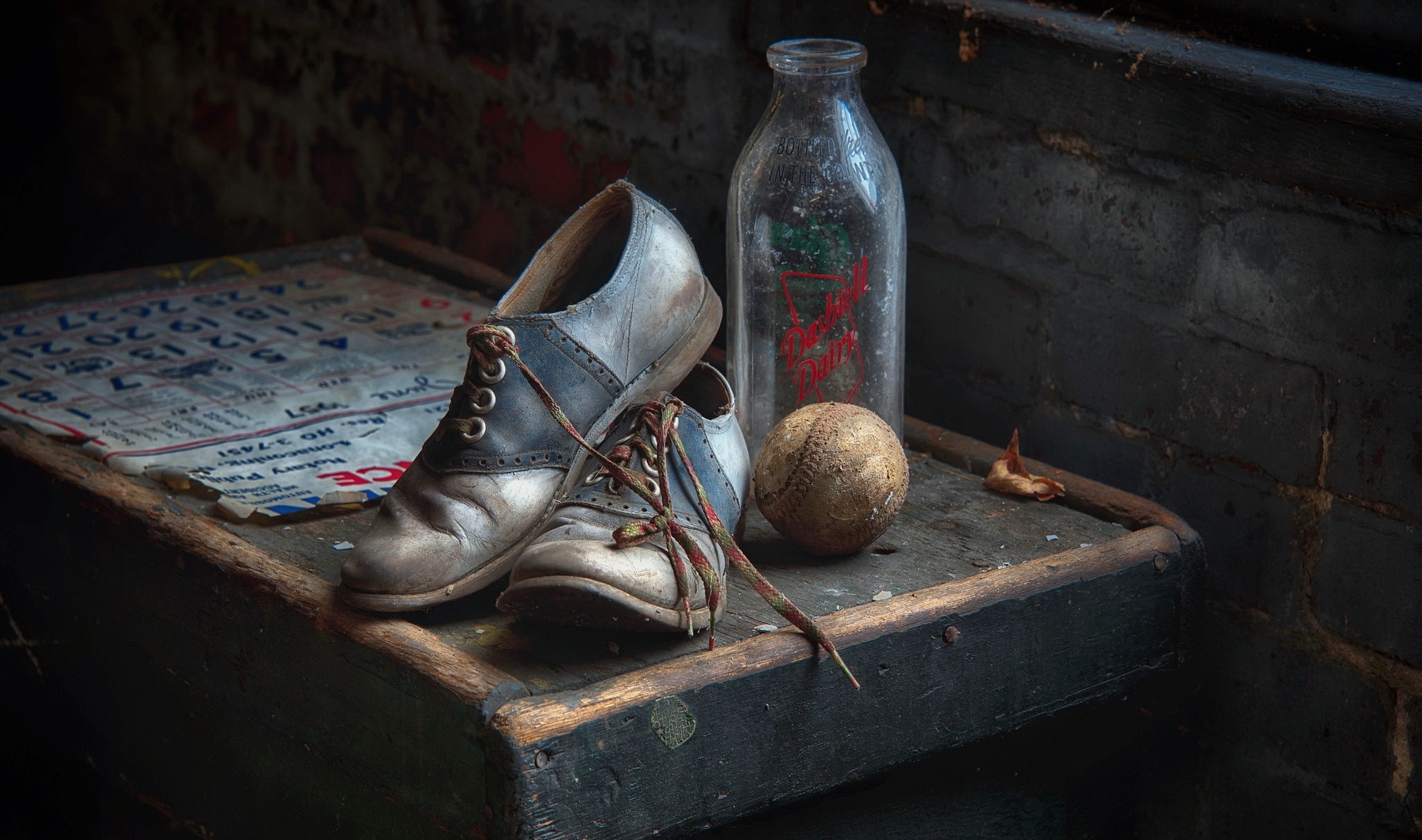 Old saddle shoes, baseball, and milk bottle on a table HD Wallpaper