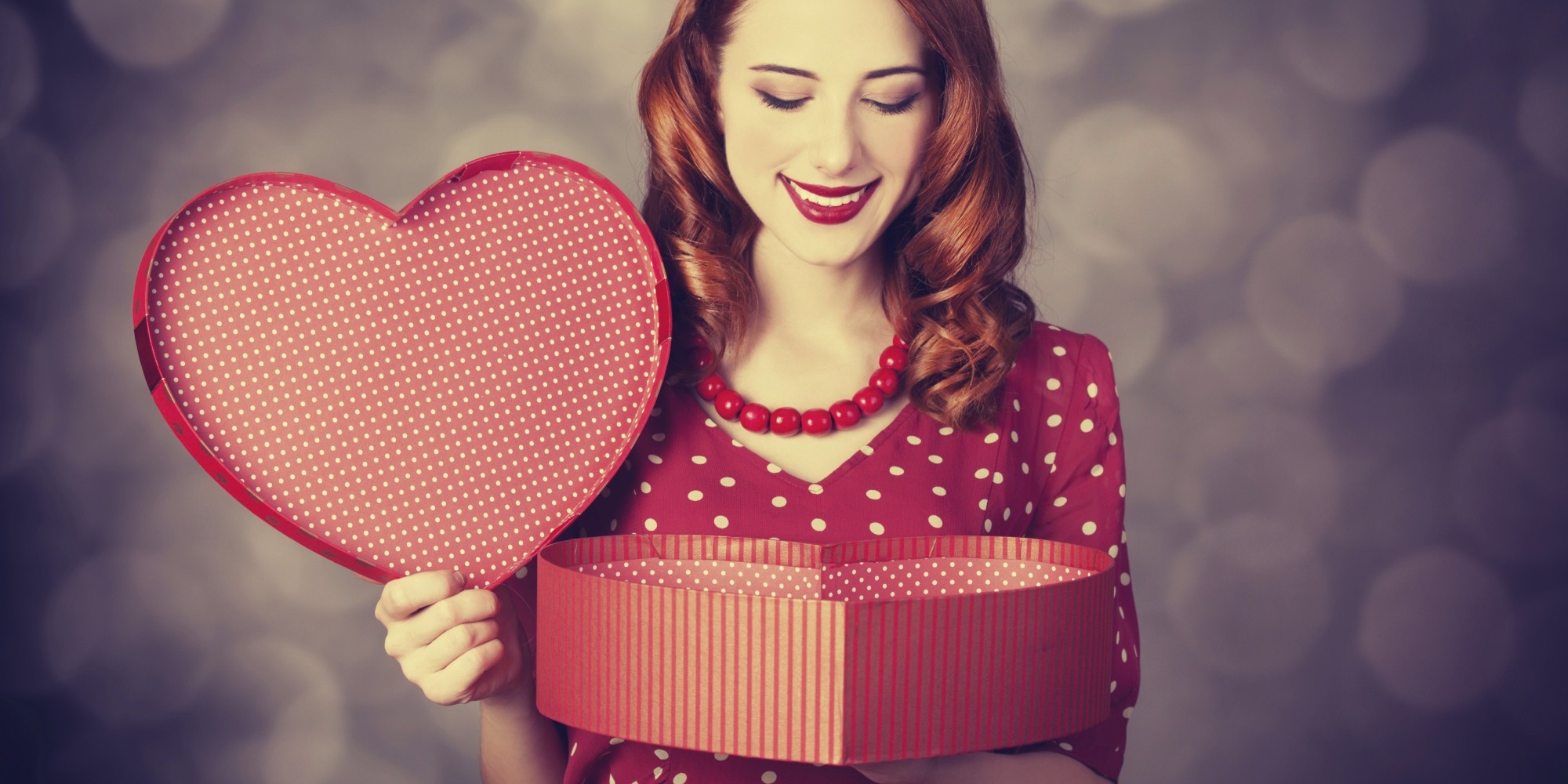 Woman in red polka dot dress holding heart-shaped box HD Wallpaper