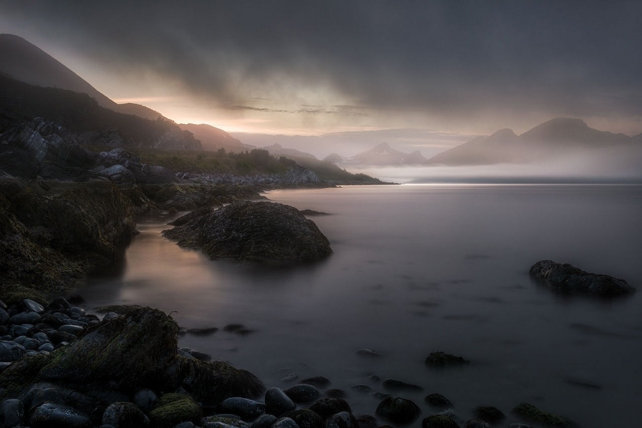 Misty mountains over a rocky shore at sunrise HD Wallpaper