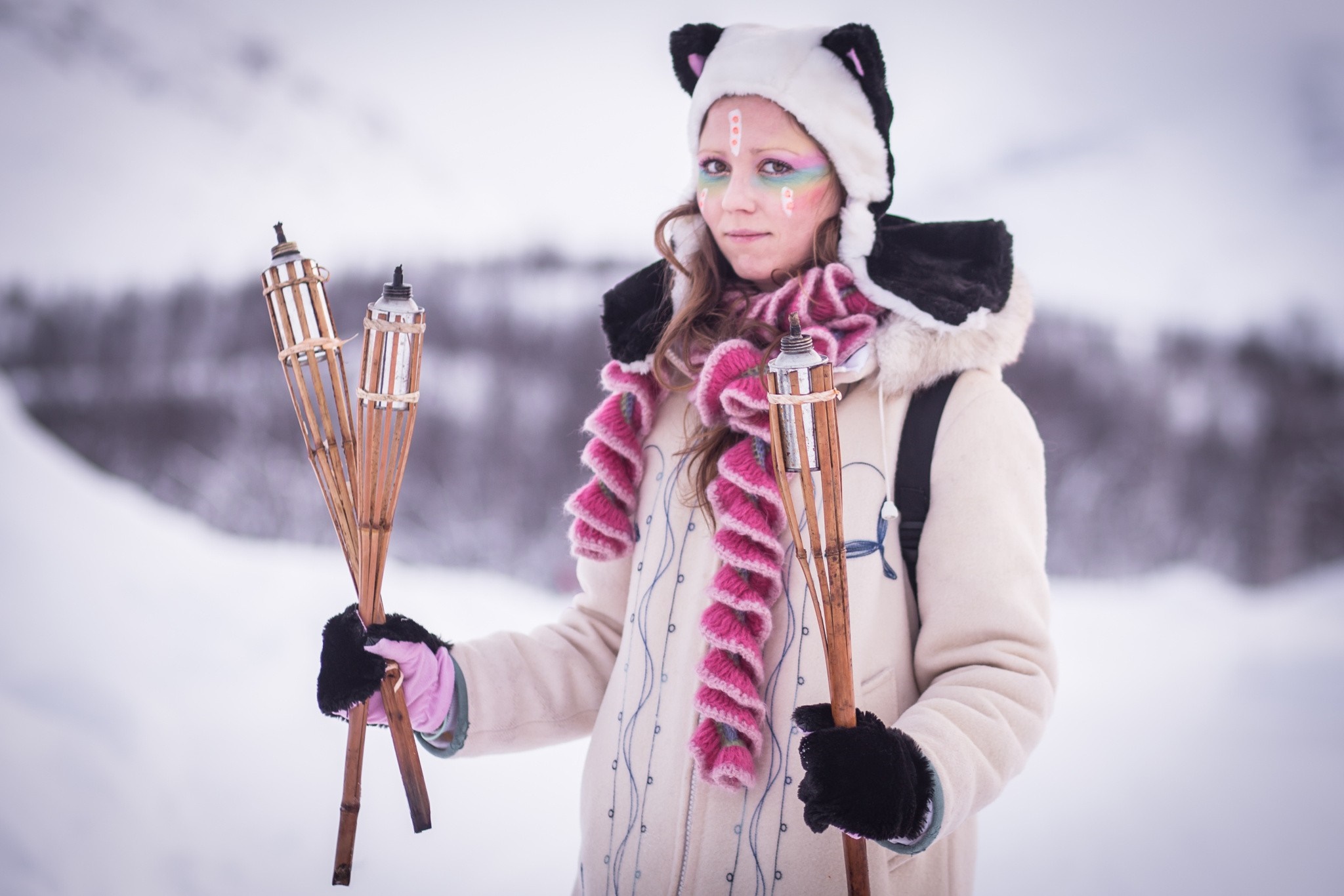 Woman in panda hat holding torches in the snow HD Wallpaper