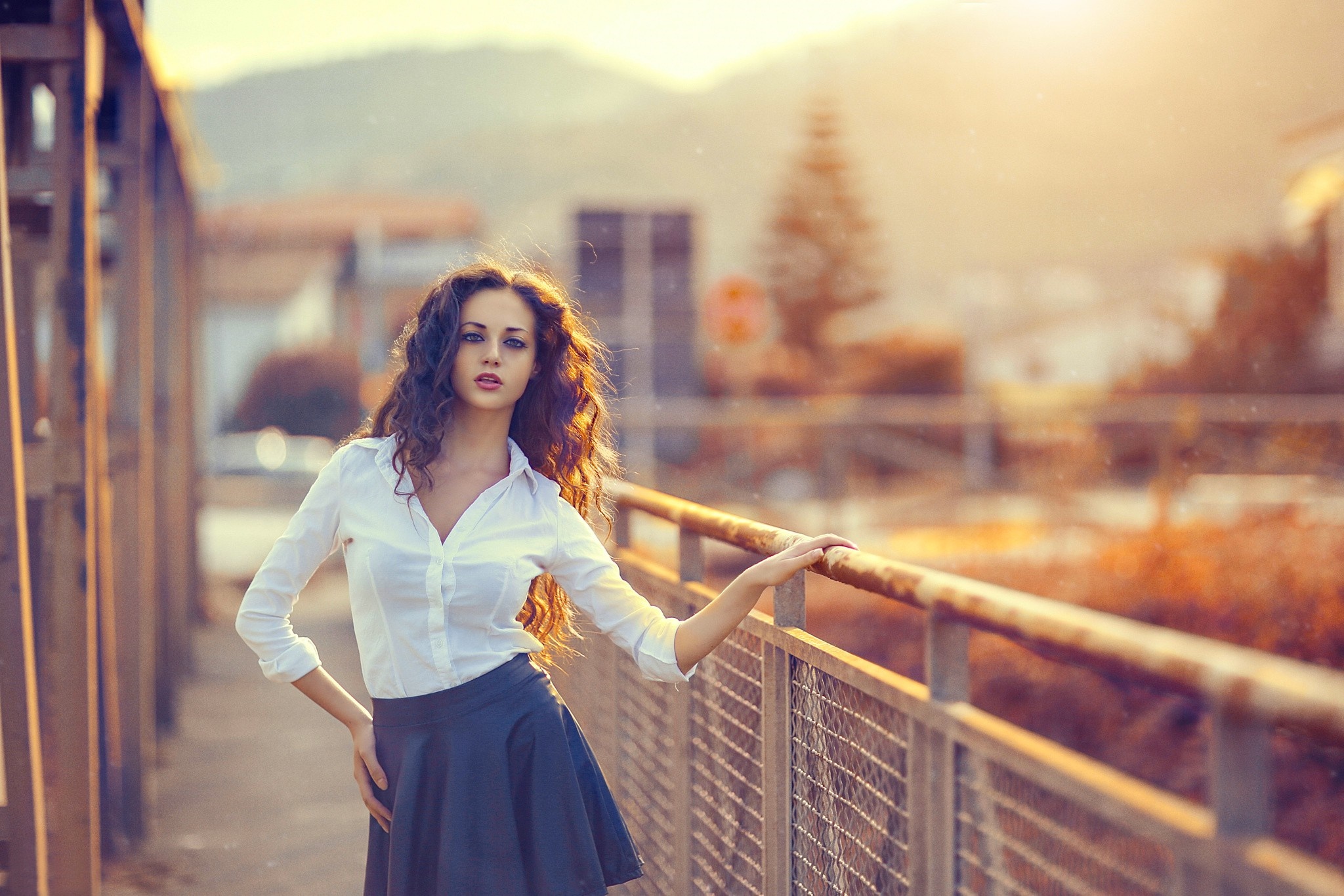 Woman with long curly hair in white shirt and blue skirt HD Wallpaper