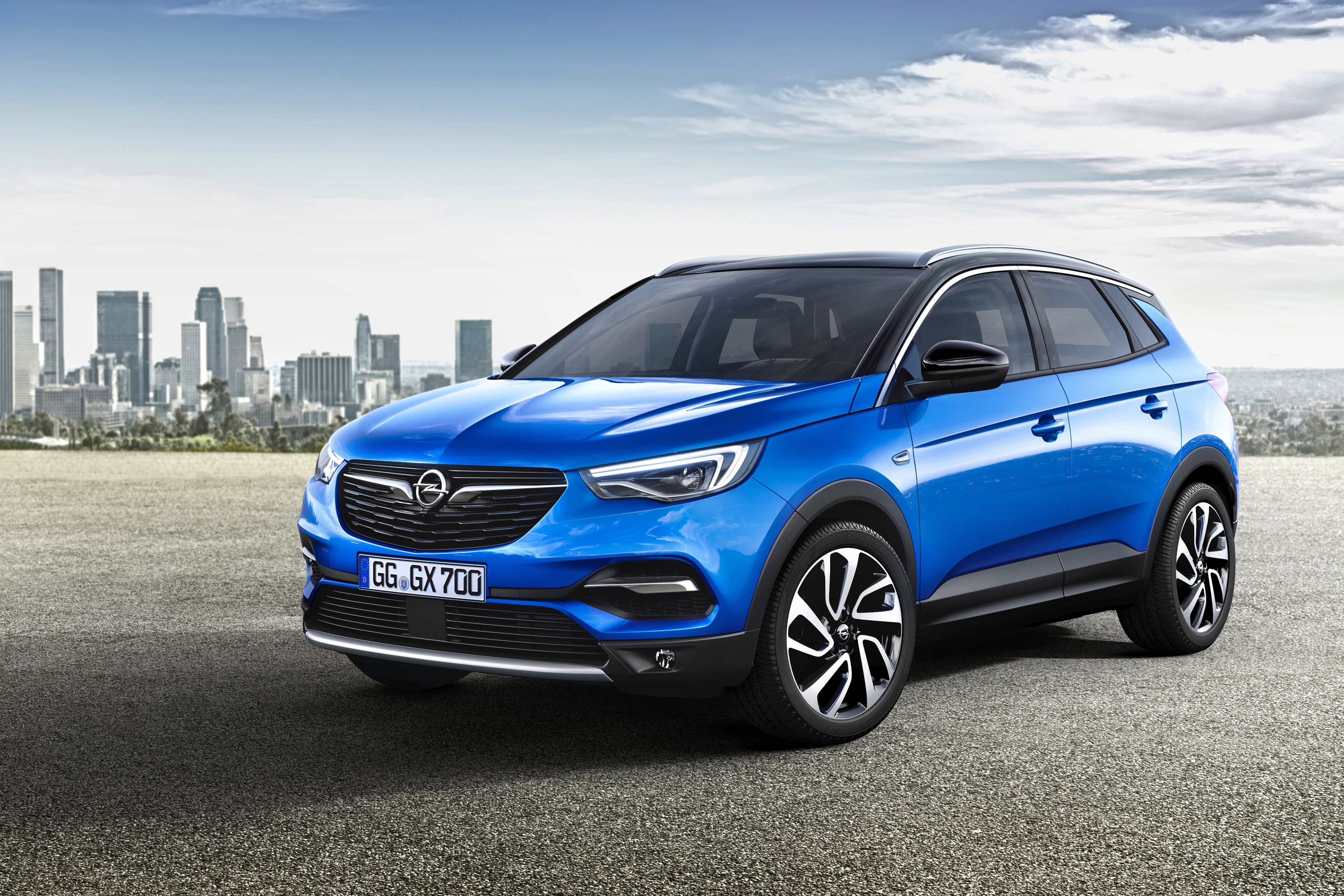 Blue Opel Grandland X crossover with city skyline HD Wallpaper