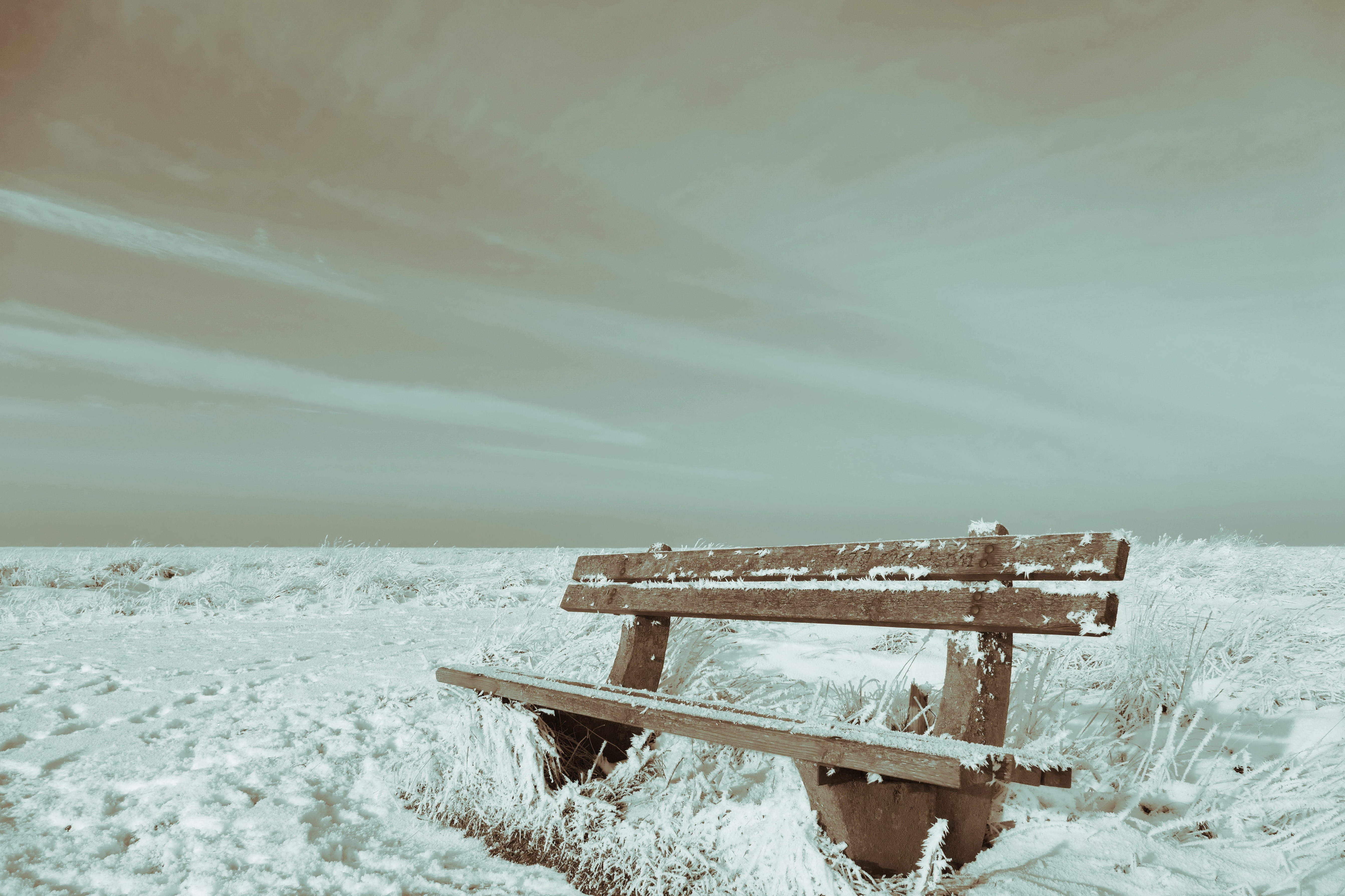 Wooden bench in a snowy landscape HD Wallpaper
