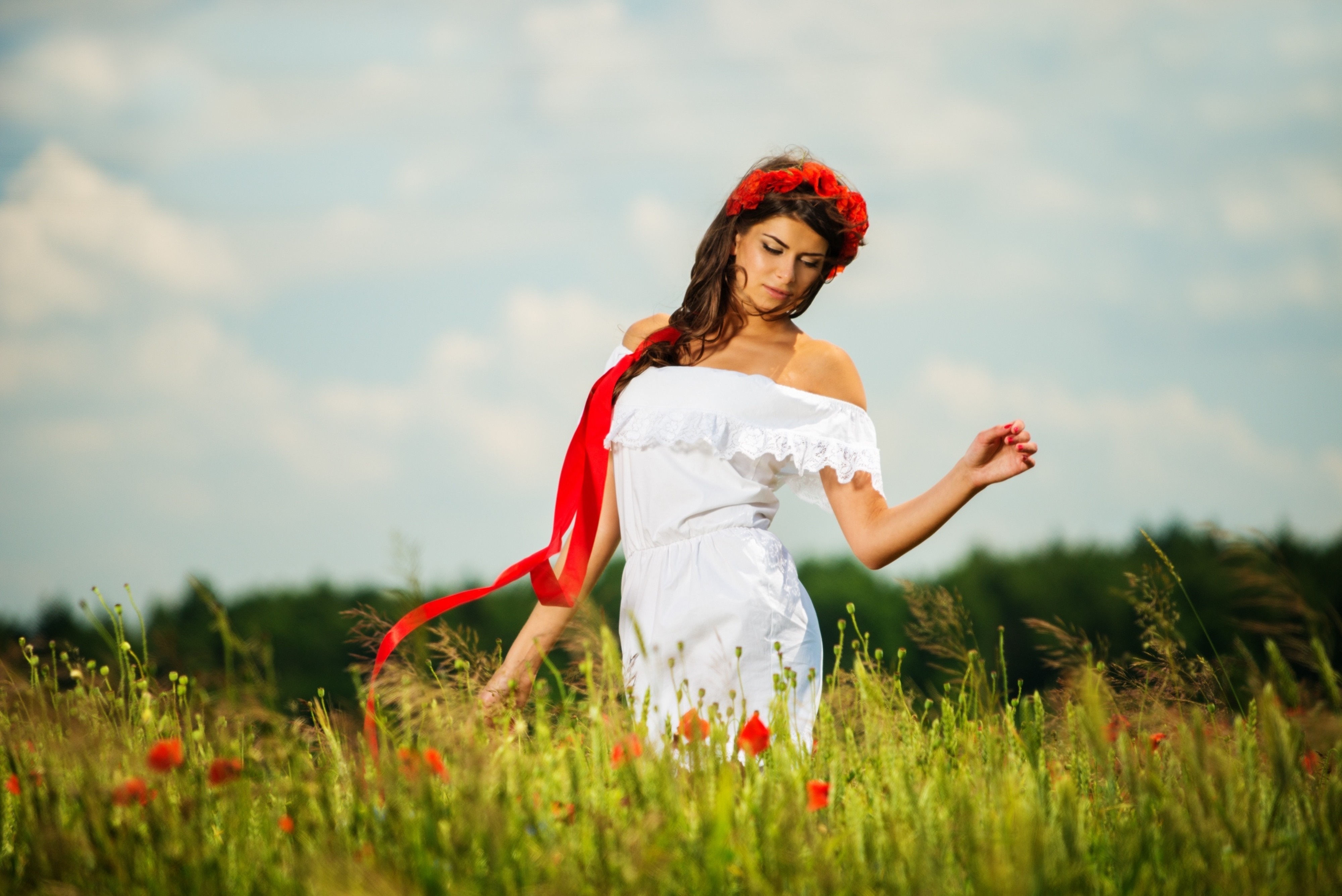 Woman in white dress with red flower crown in a field HD Wallpaper
