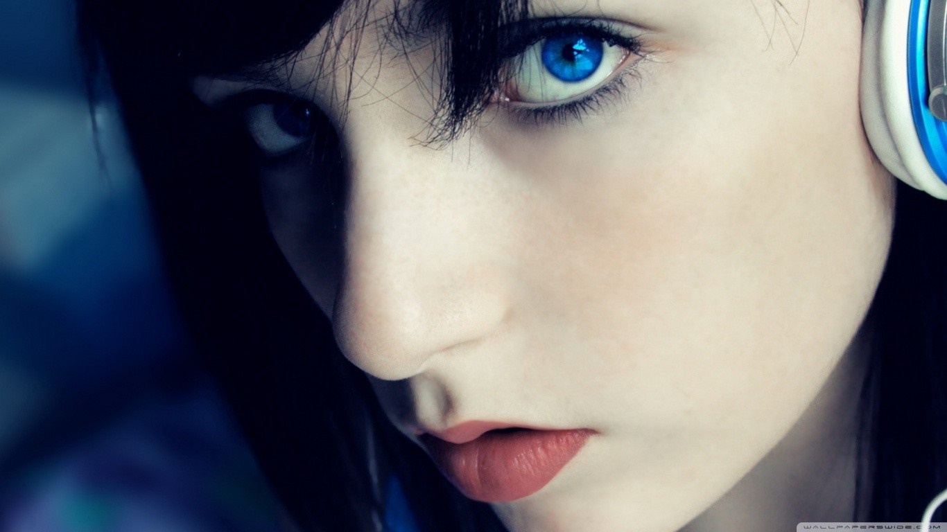 Close-up portrait of a young woman with blue eyes and headphones HD Wallpaper