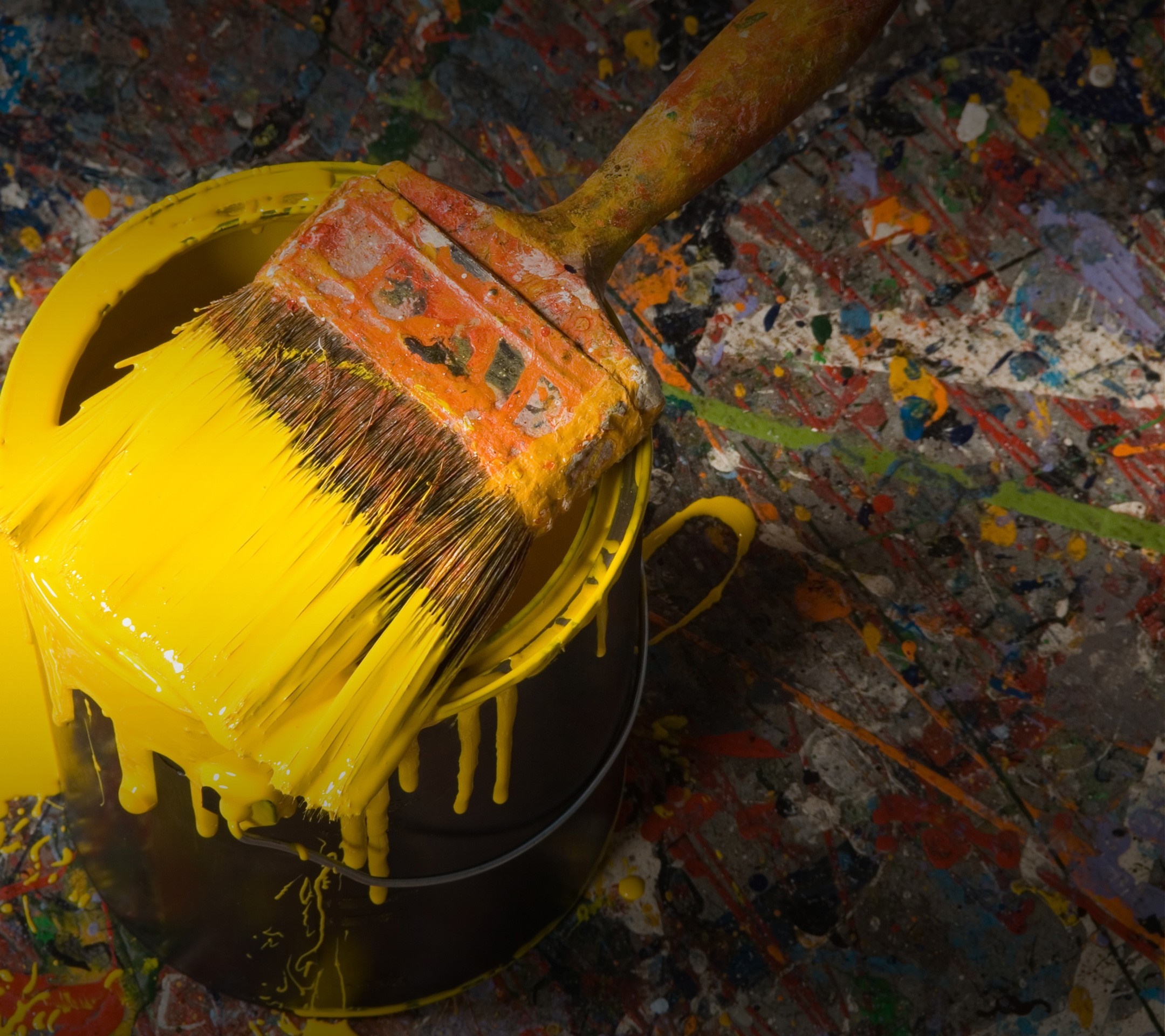 Paintbrush with yellow paint in a paint can HD Wallpaper