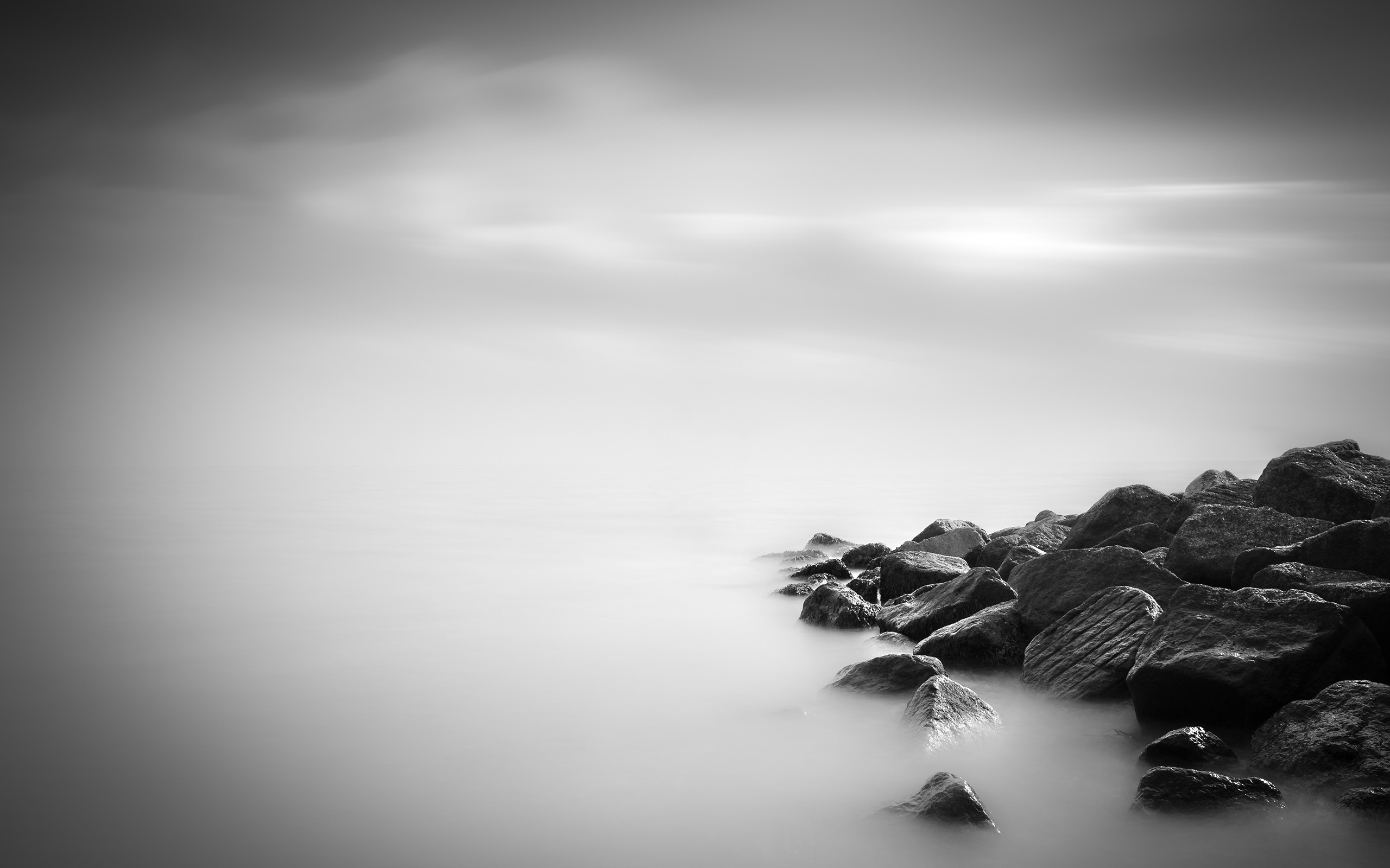Monochrome coast with rocks and blurred sky HD Wallpaper