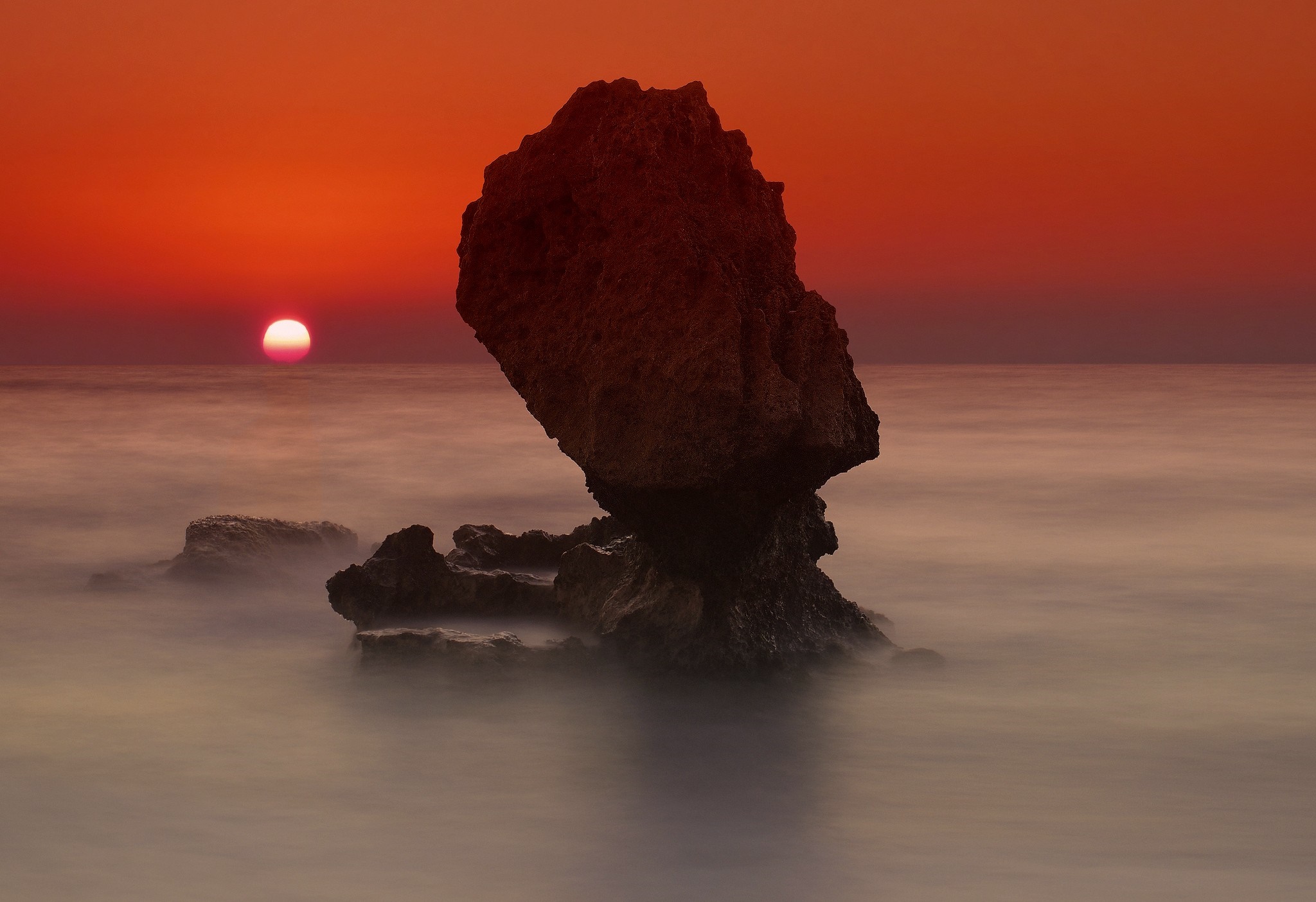 Rock formation in the sea at sunset HD Wallpaper