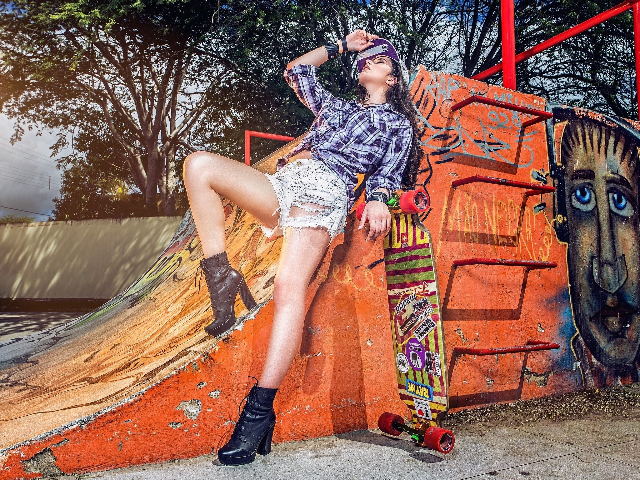 Woman in plaid shirt and ripped shorts with skateboard HD Wallpaper