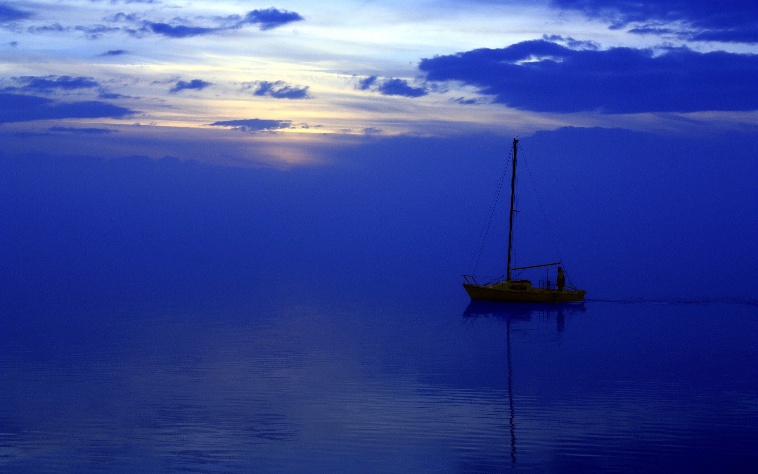Yellow sailboat on blue water at sunset HD Wallpaper