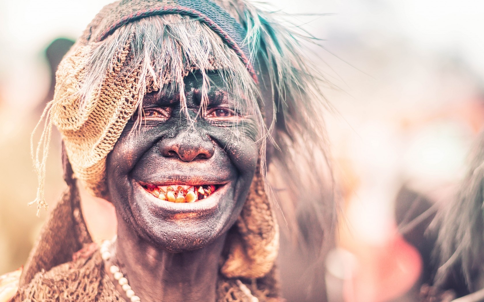 Person with face paint and headdress at a festival HD Wallpaper