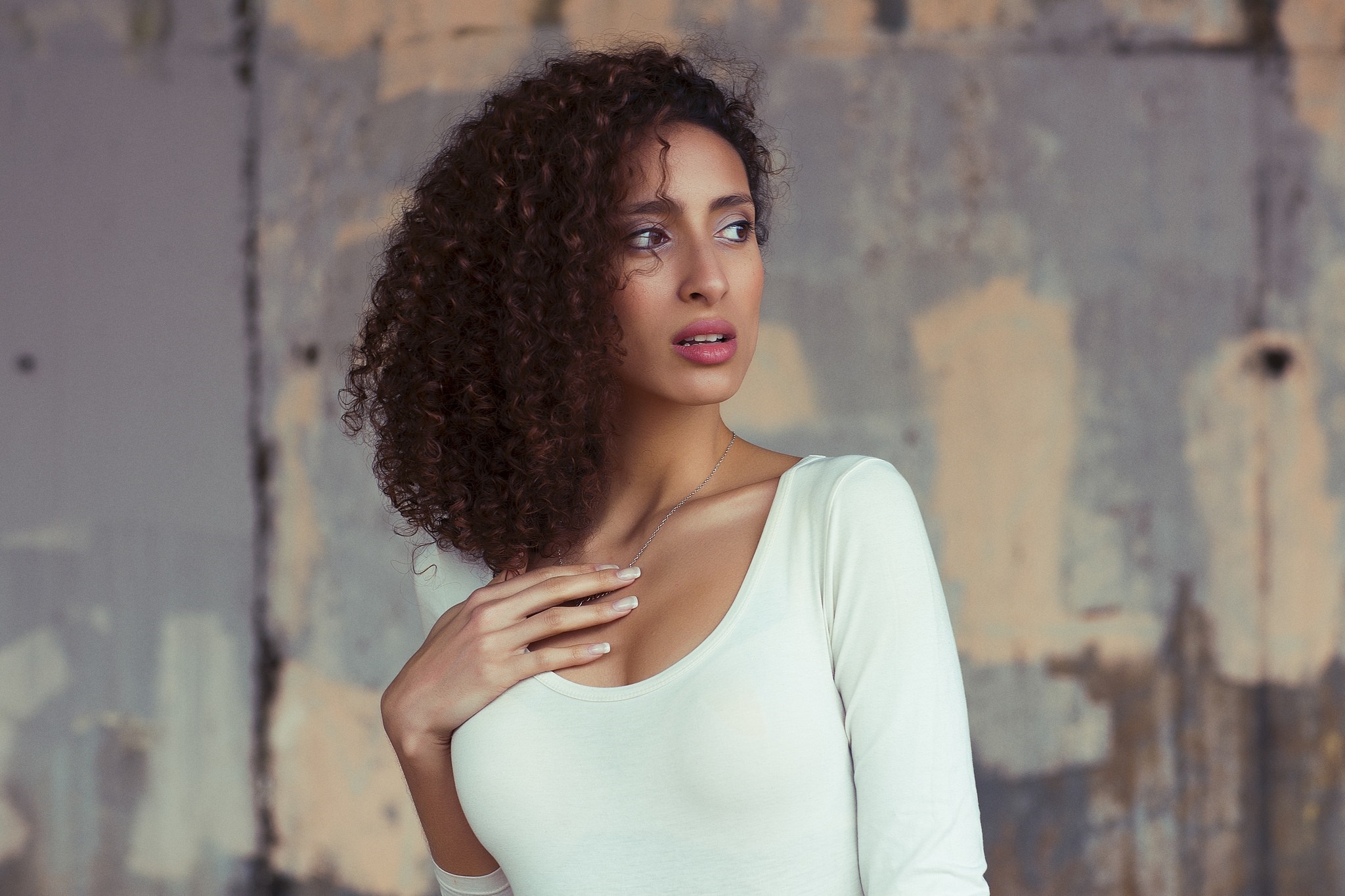 Woman with curly brown hair wearing a white top HD Wallpaper