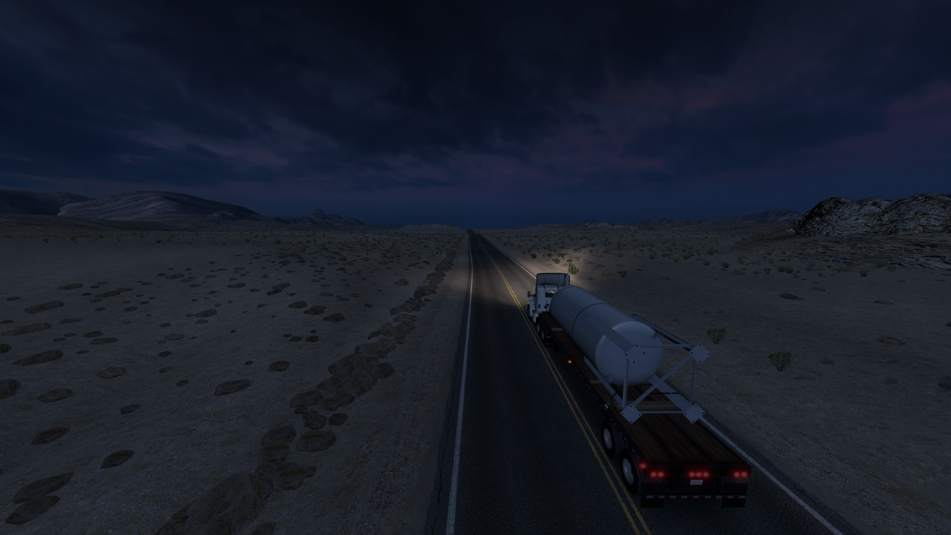 Truck hauling a tank trailer on a desert highway at night HD Wallpaper