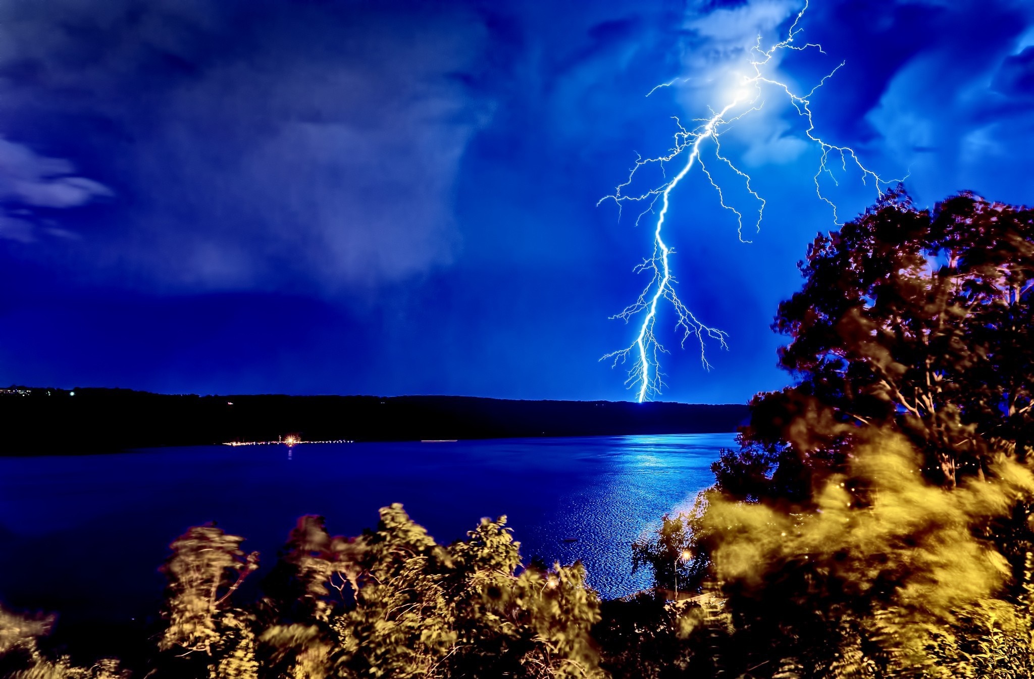 Lightning strike over a body of water at night HD Wallpaper
