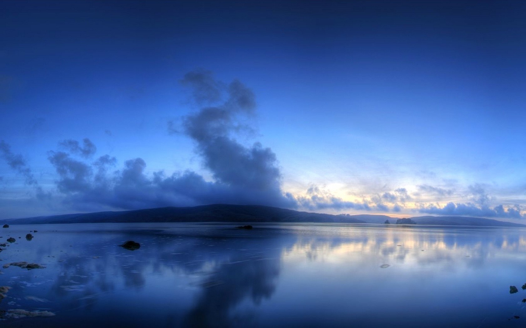 Calm lake reflecting a cloudy sky at dusk HD Wallpaper