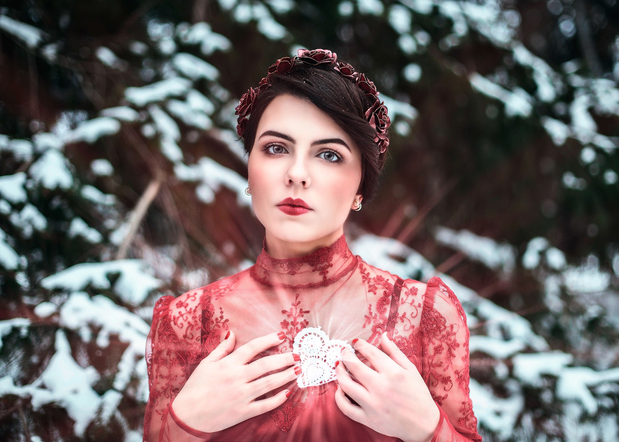 Woman in red dress with heart brooch in winter forest HD Wallpaper