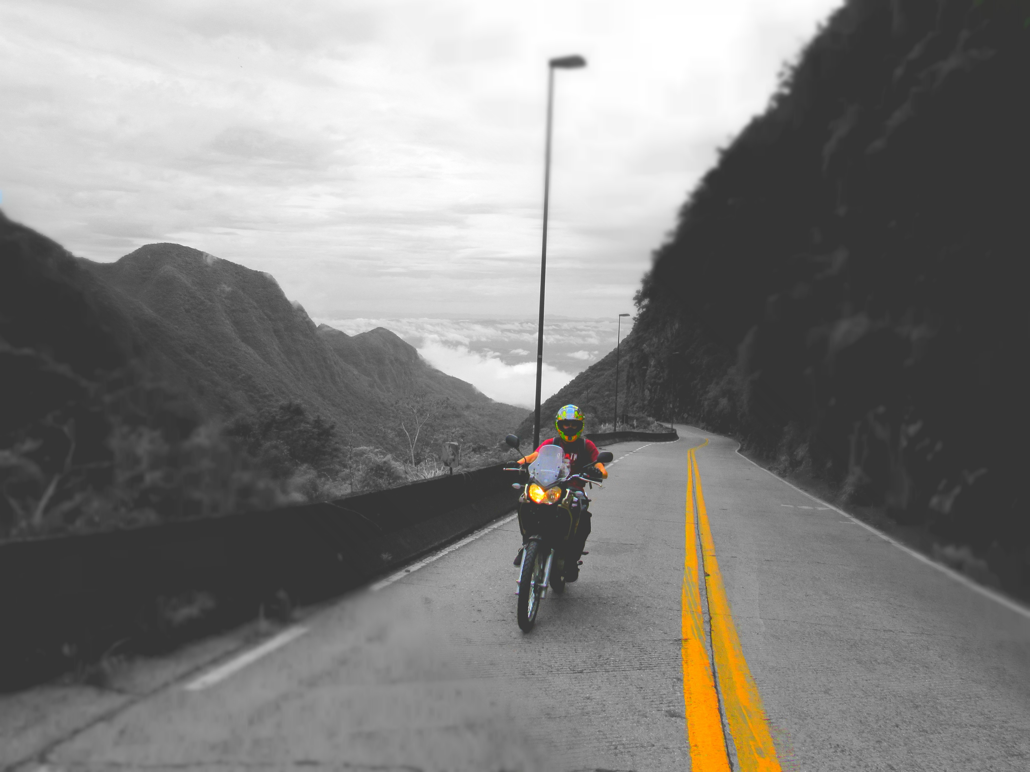 Motorcyclist on a mountain road with selective coloring HD Wallpaper