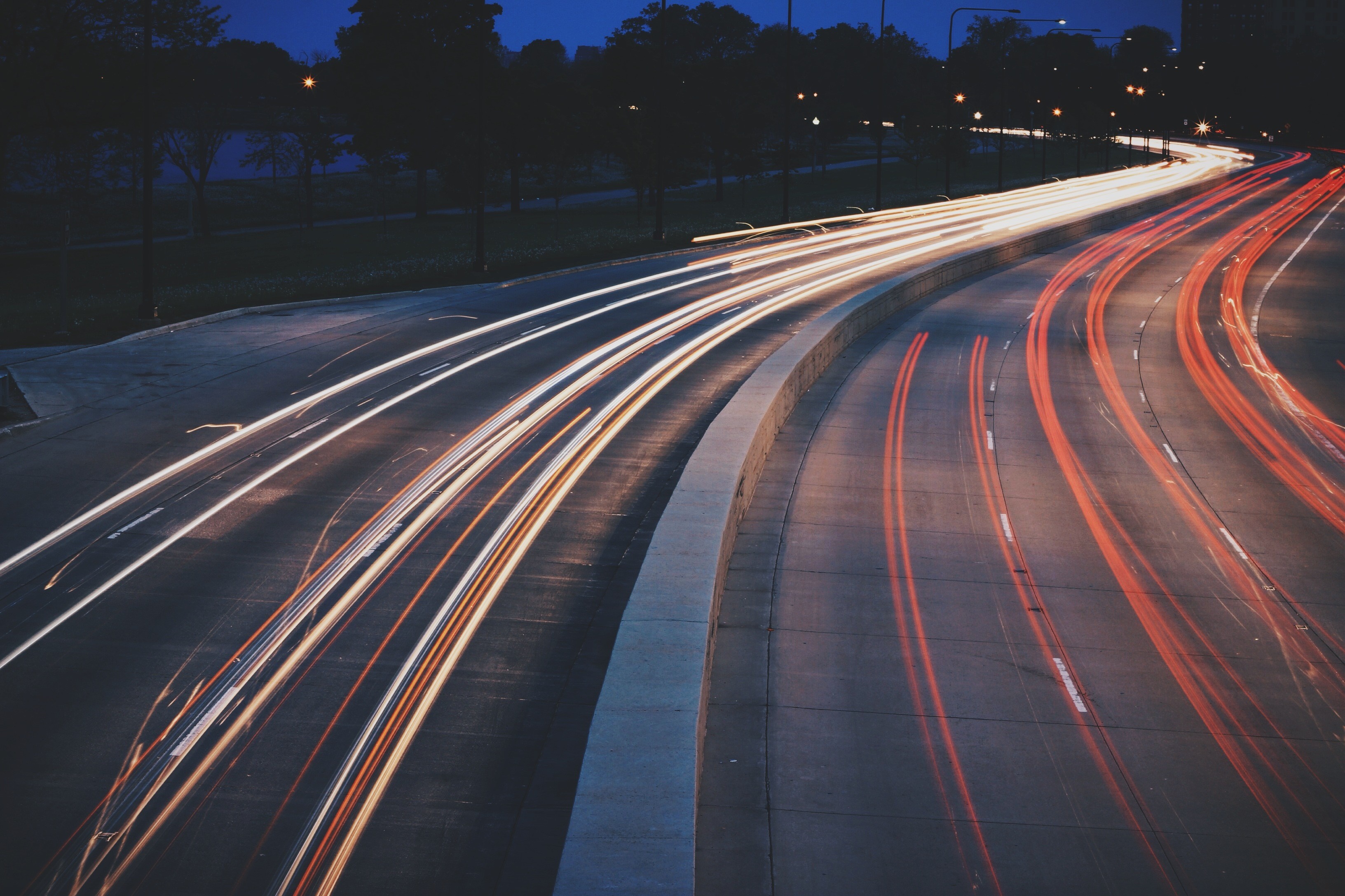 Light trails on a highway at dusk HD Wallpaper