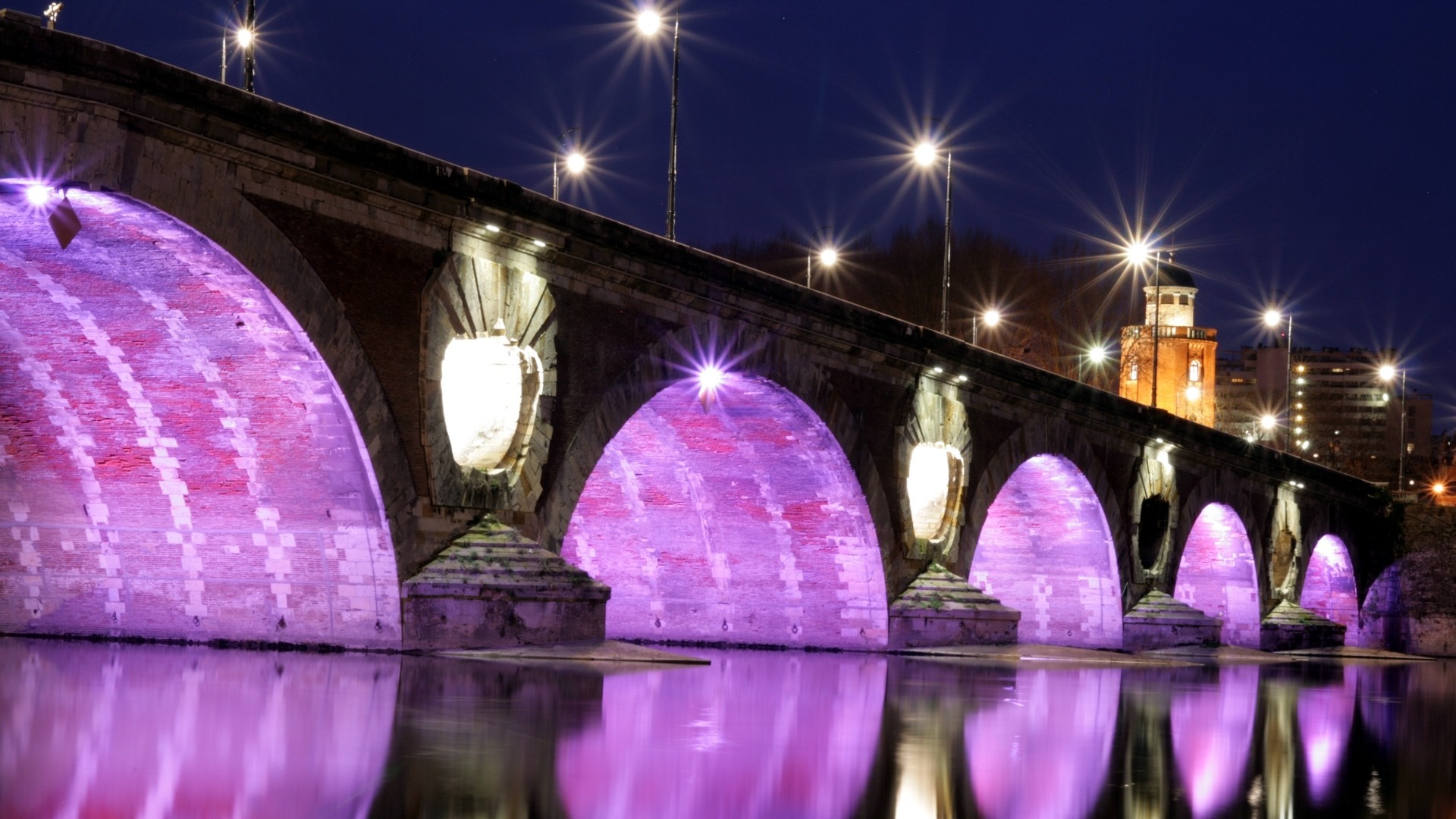 Pont Neuf bridge illuminated at night over the Garonne River in Toulouse, France HD Wallpaper