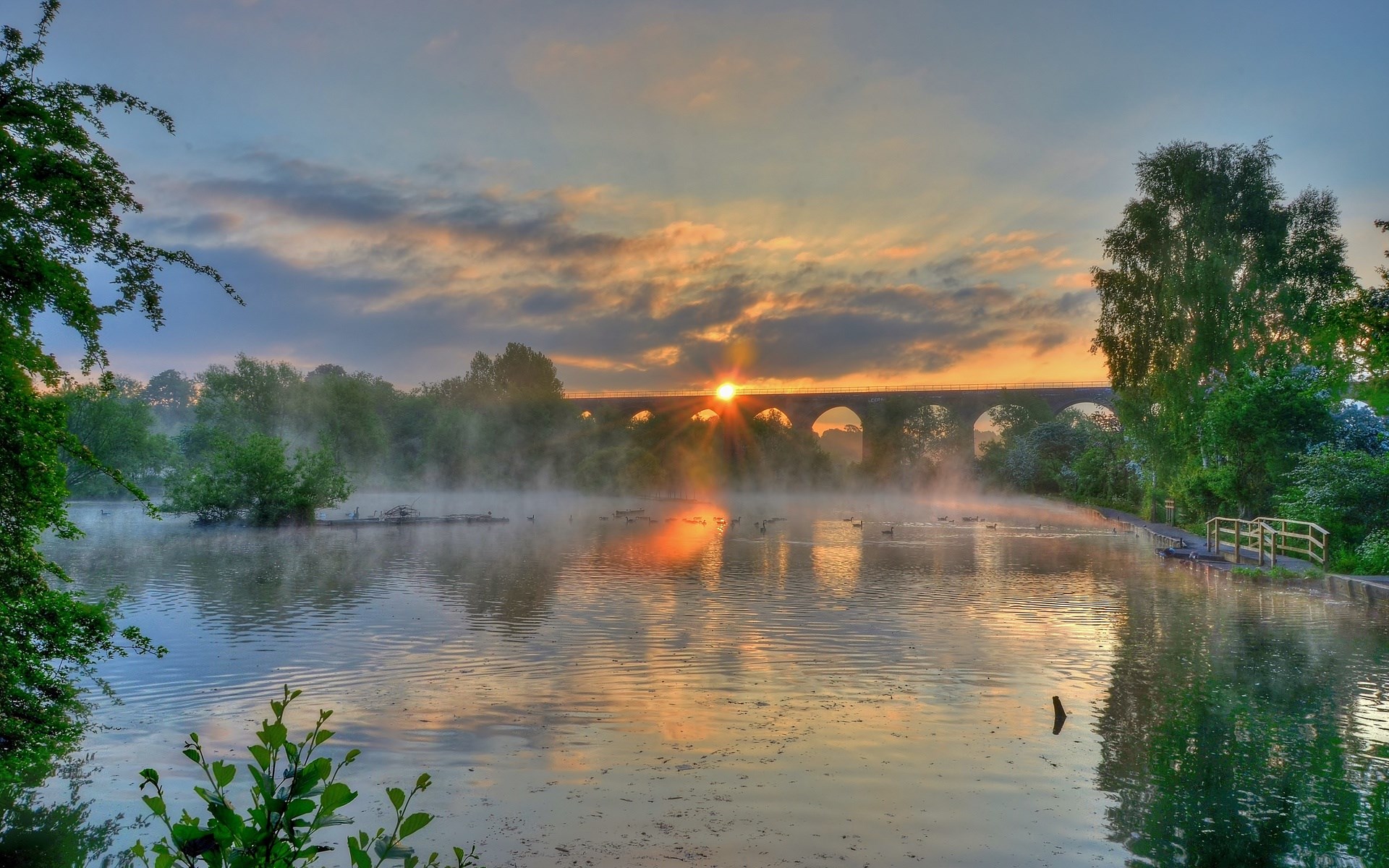 Sunrise over a misty lake with a viaduct HD Wallpaper