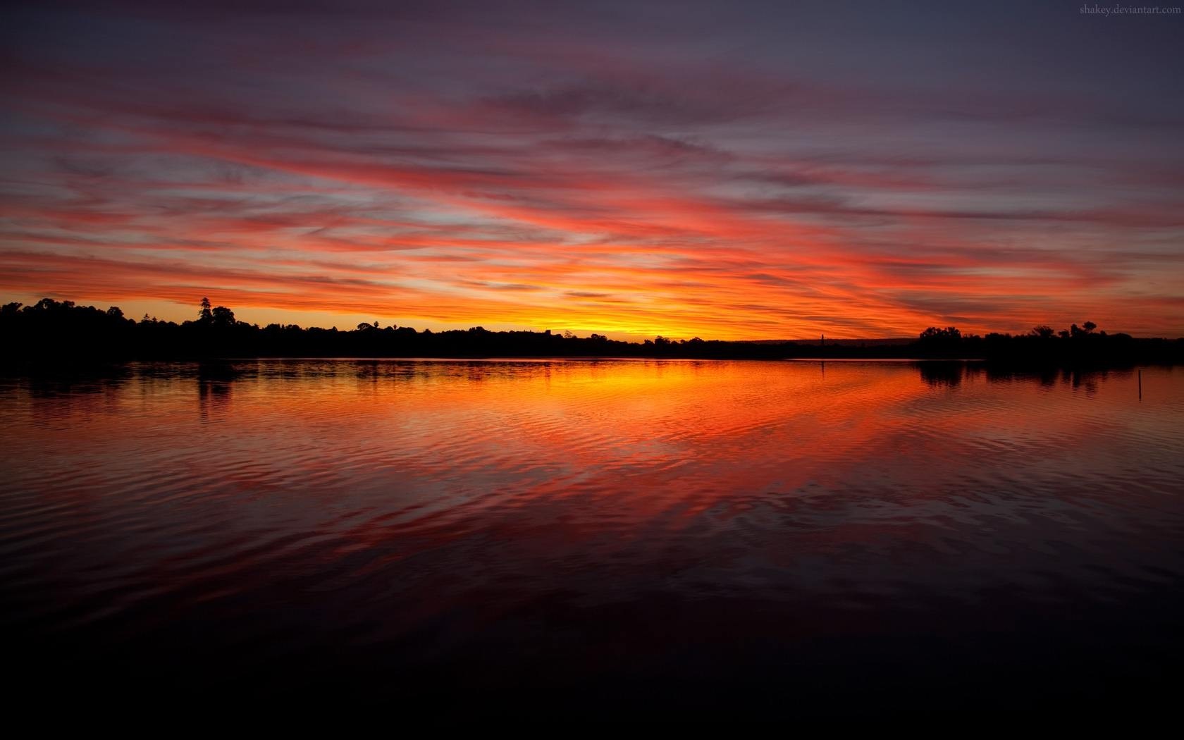 Sunset over a lake with colorful clouds and reflection HD Wallpaper