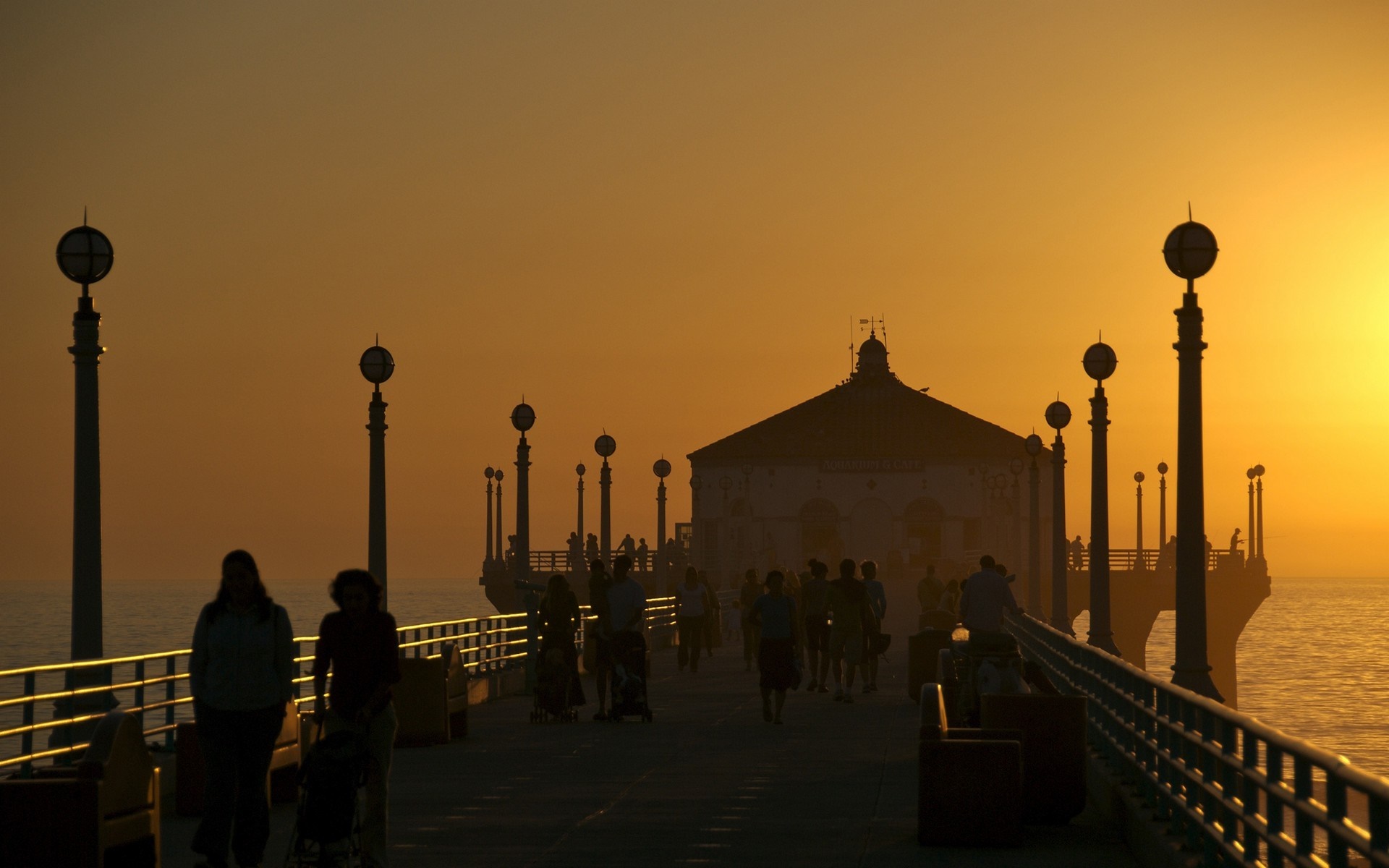 People walking on a pier at sunset HD Wallpaper