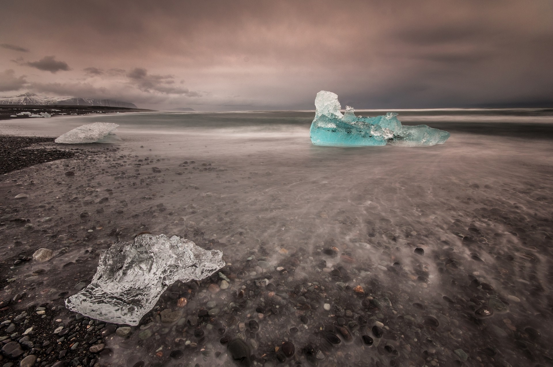 Icebergs on a black sand beach with ocean waves HD Wallpaper