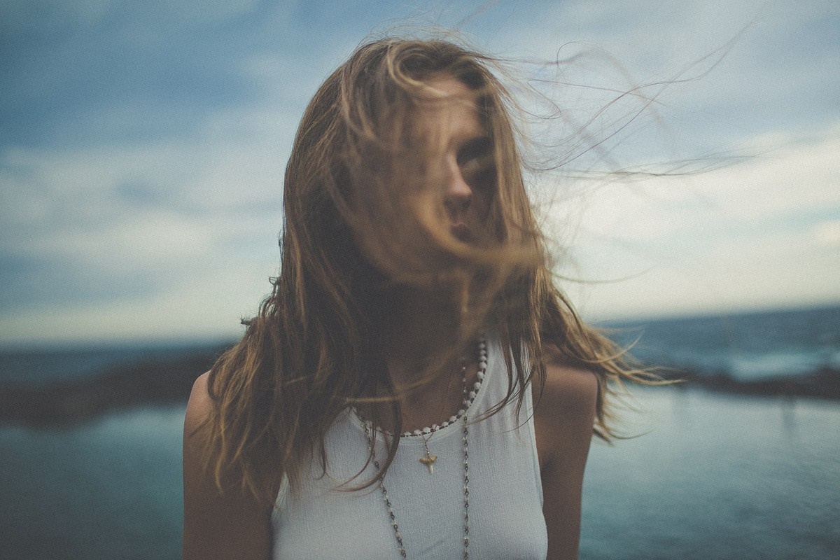 Woman with windblown hair by the sea HD Wallpaper